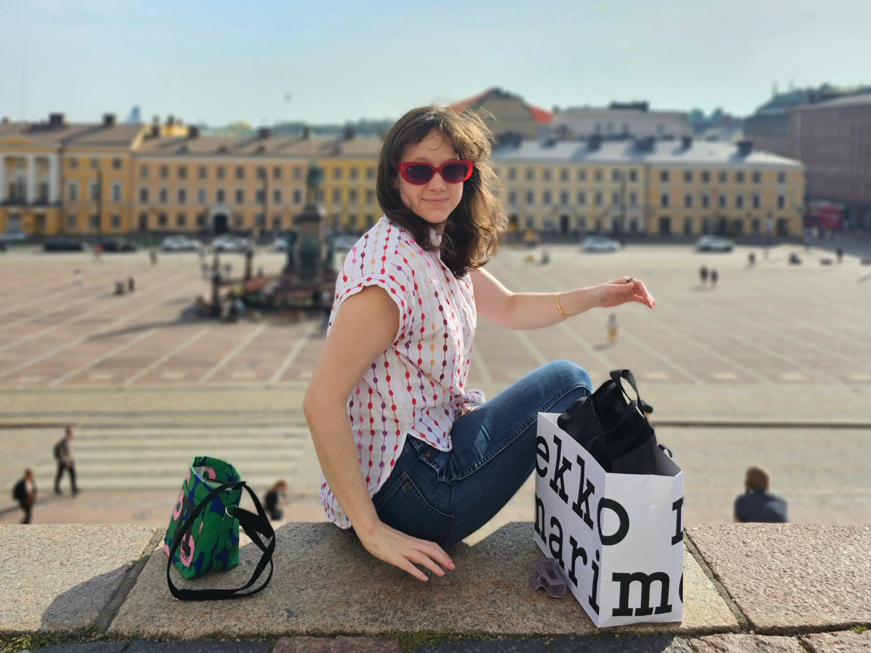 Anya sits on a stone ledge overlooking Helsinki's Senate Square.