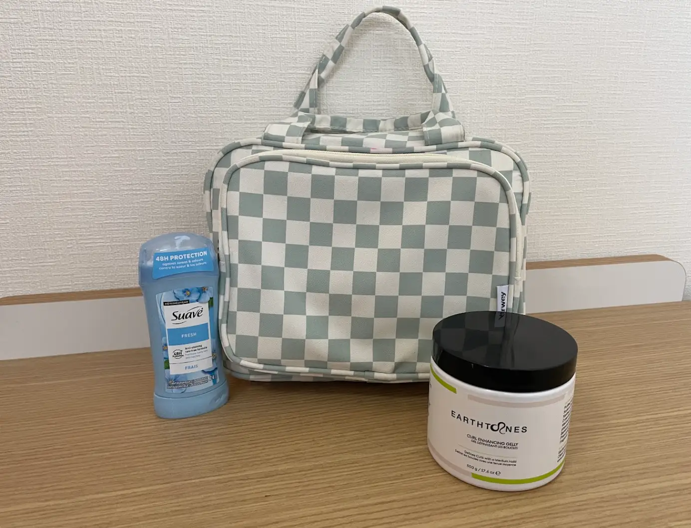 A checkered bag next to Suave deodorant and curl-enhancing gel.