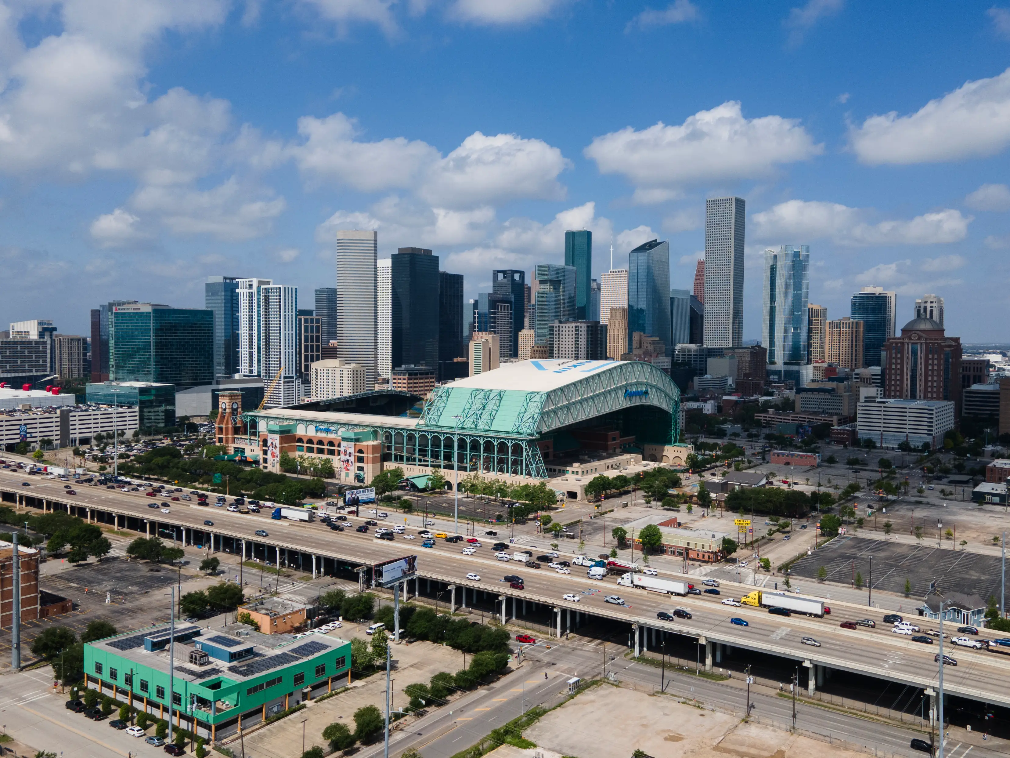 A city skyline during the day, with a freeway in the foreground.