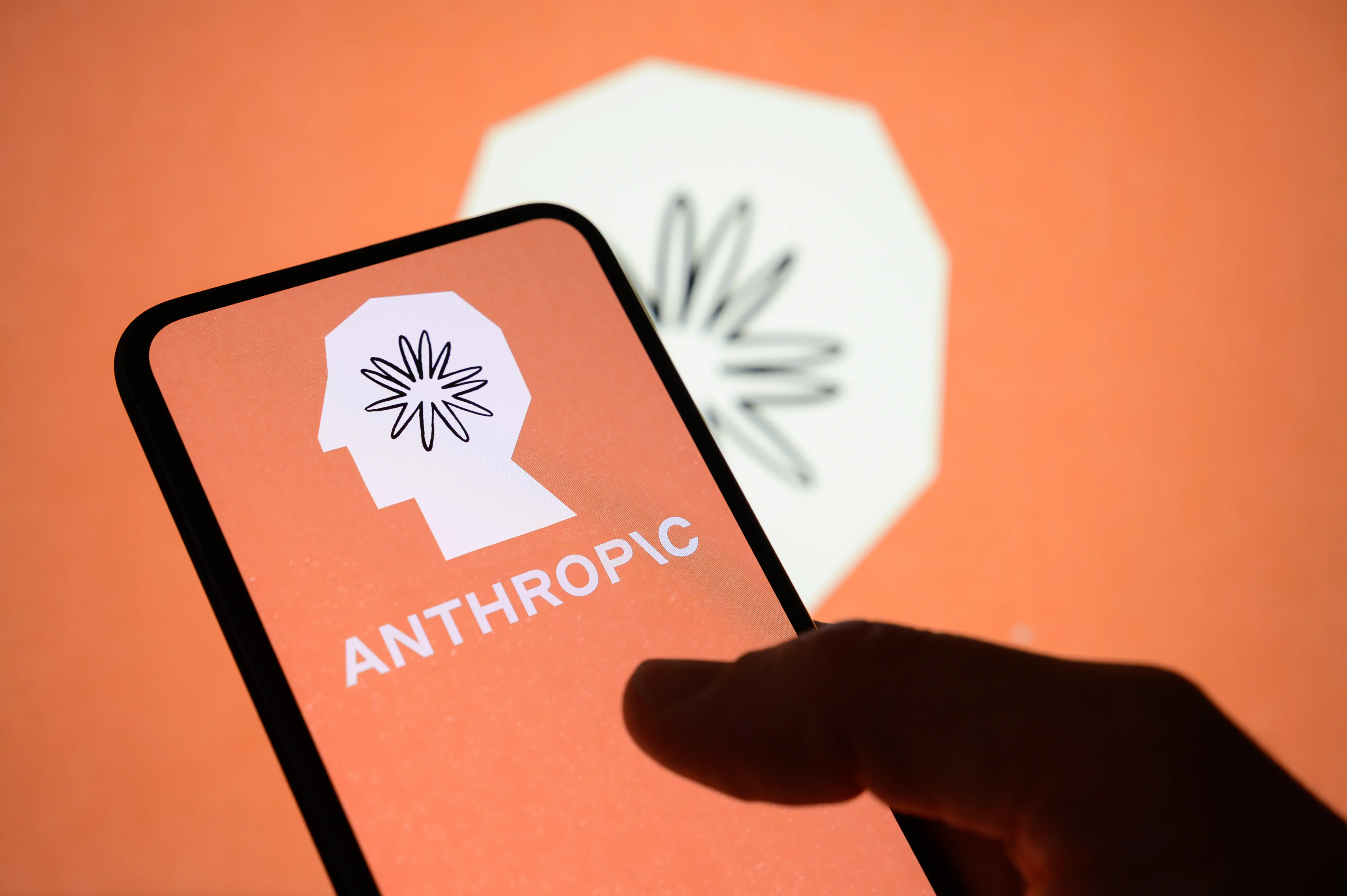 Anthropic logo is displayed on the screen of a handheld smartphone