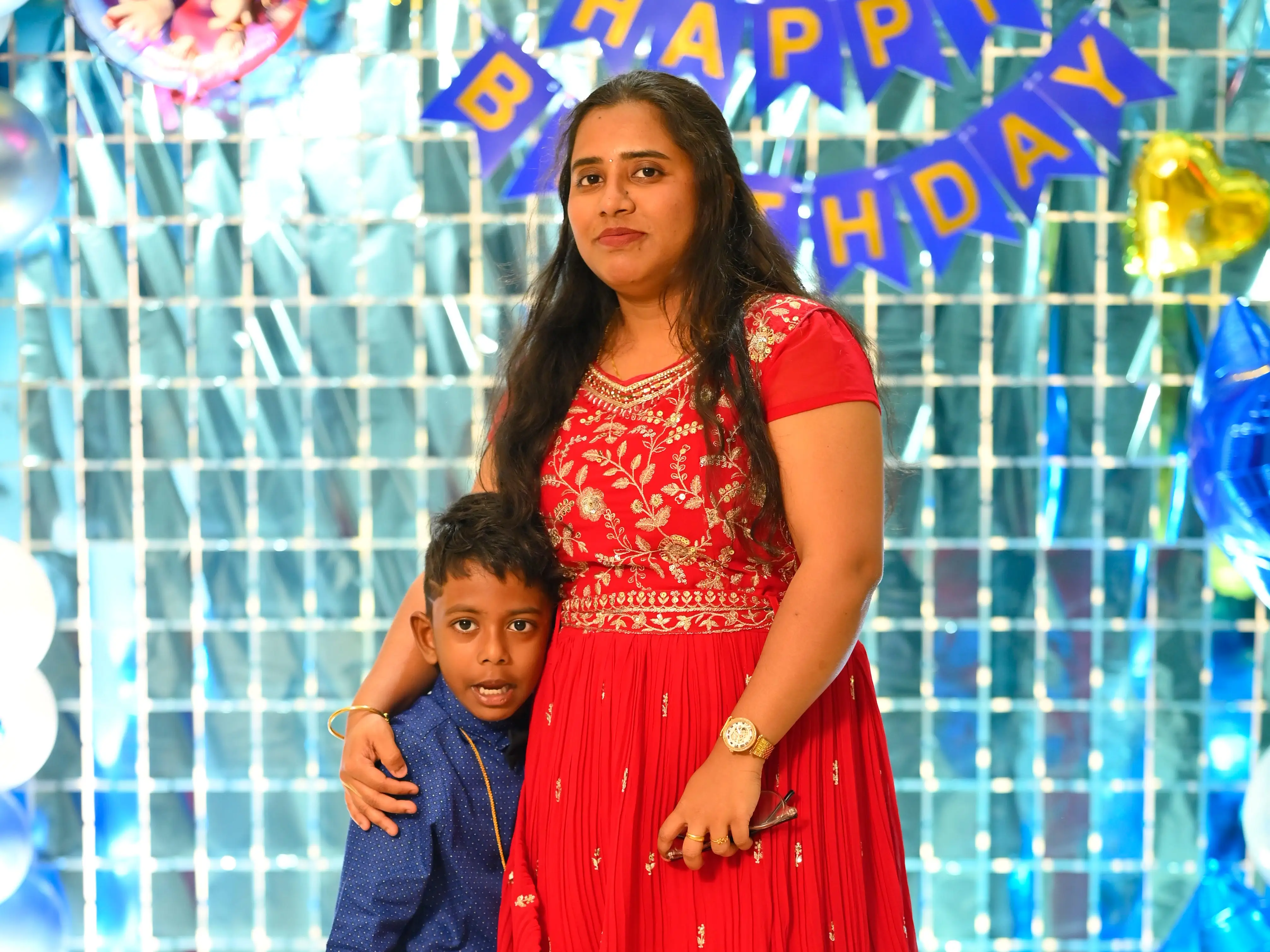 Mounika Chinnam is standing with her son in front of some
