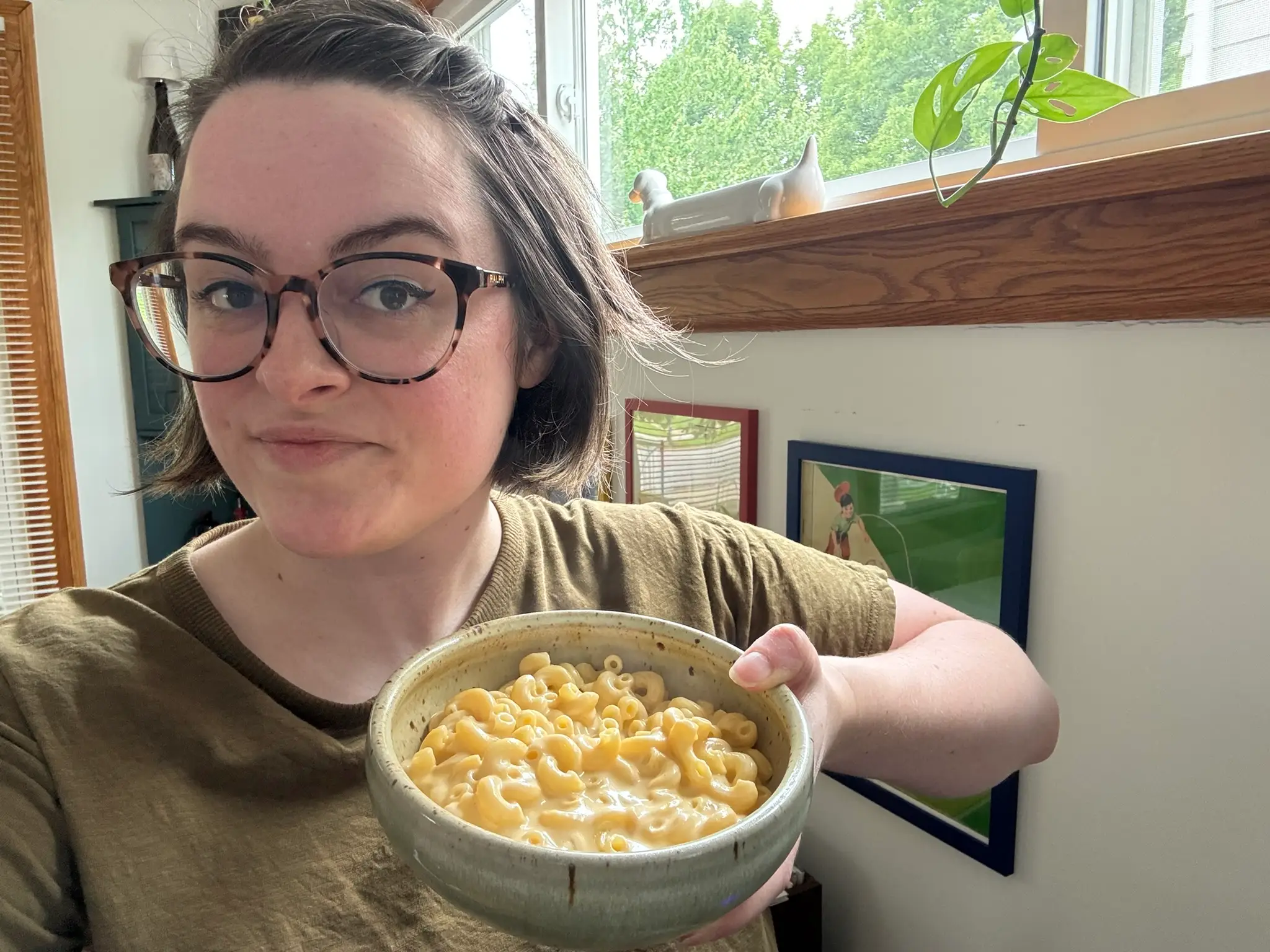 The writer is holding a bowl of protein-packed mac and cheese.
