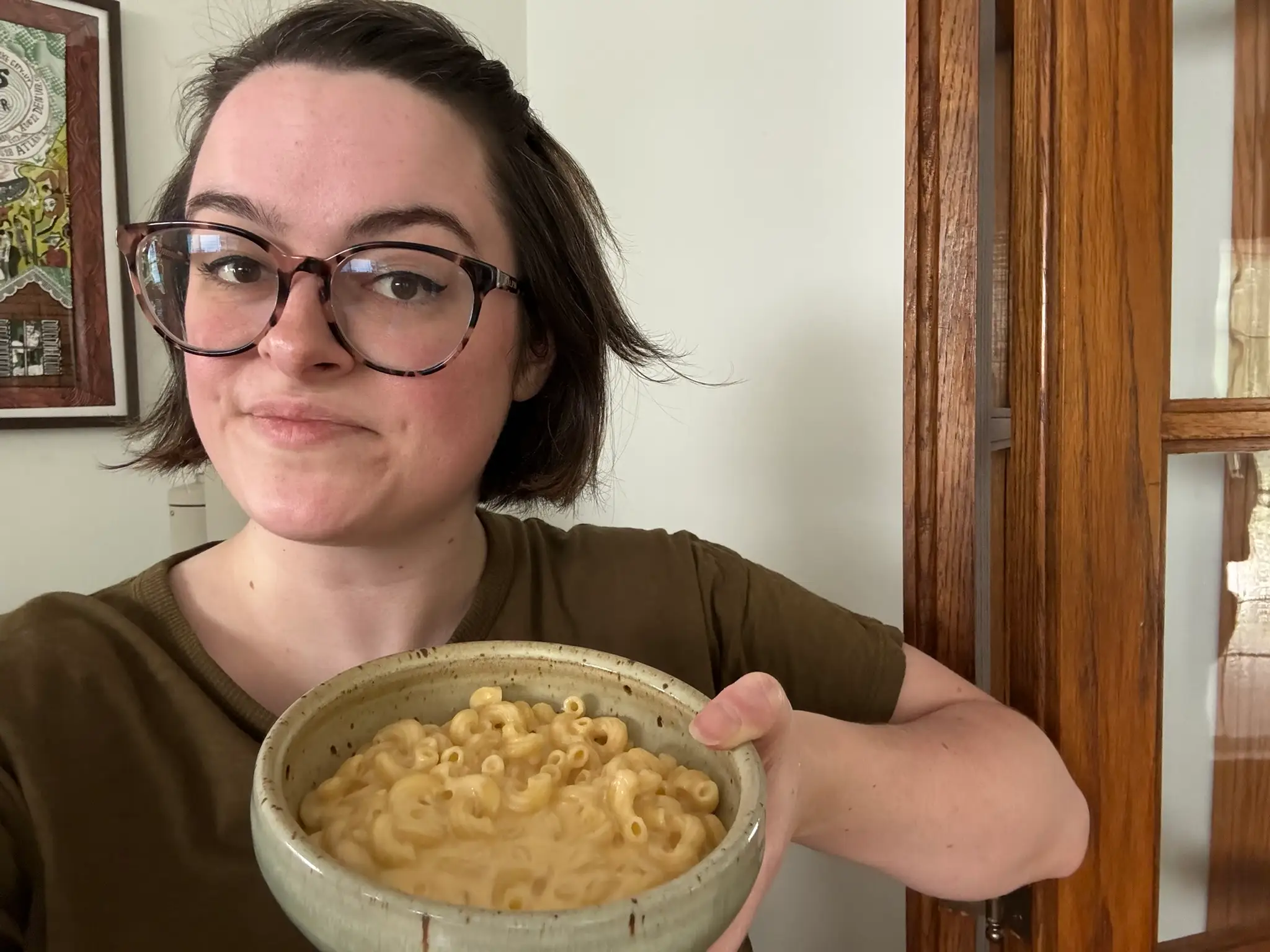 The writer is holding a bowl of mac and cheese.