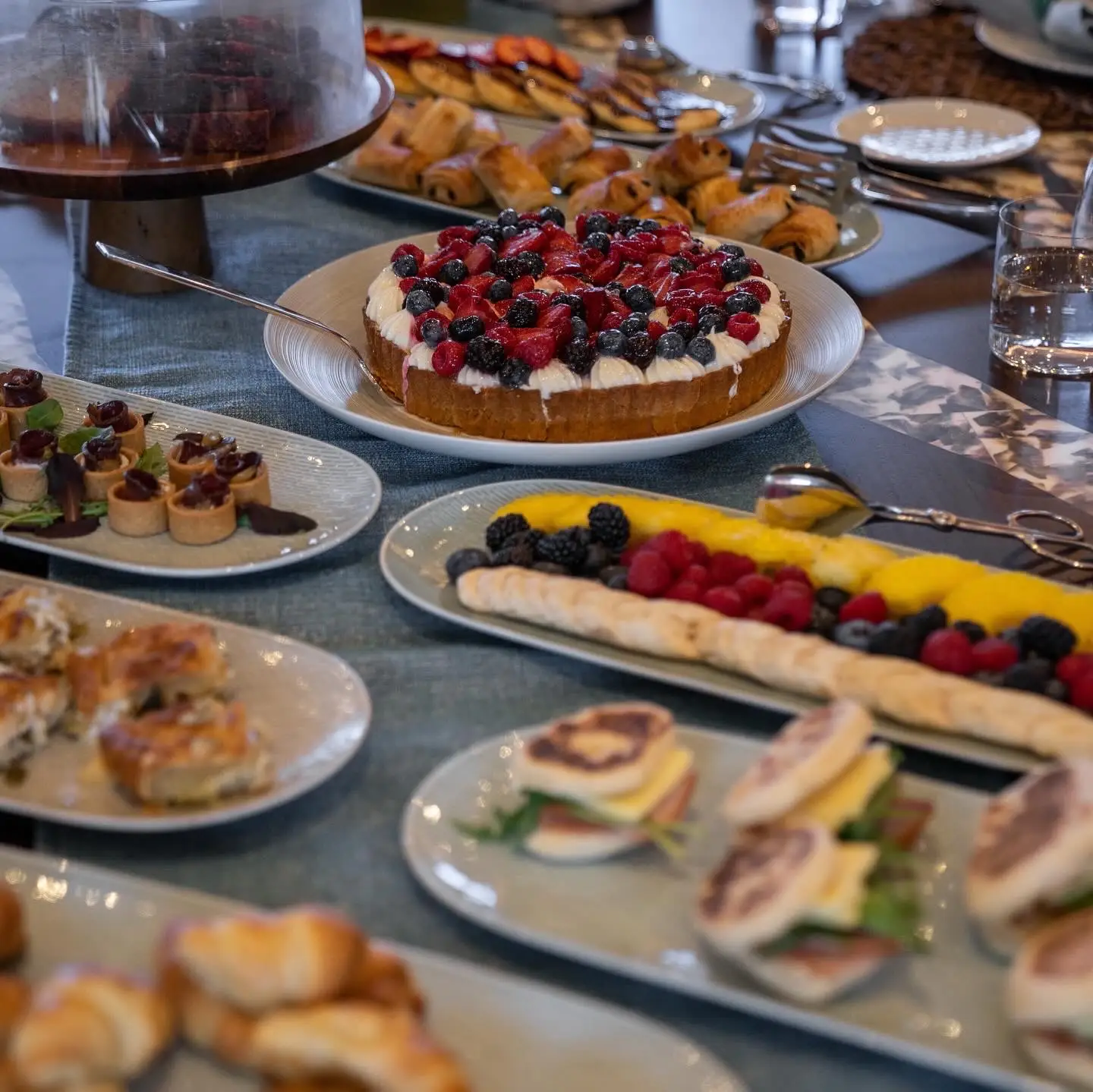 Fruit, berry-covered dessert, and other dishes on plates