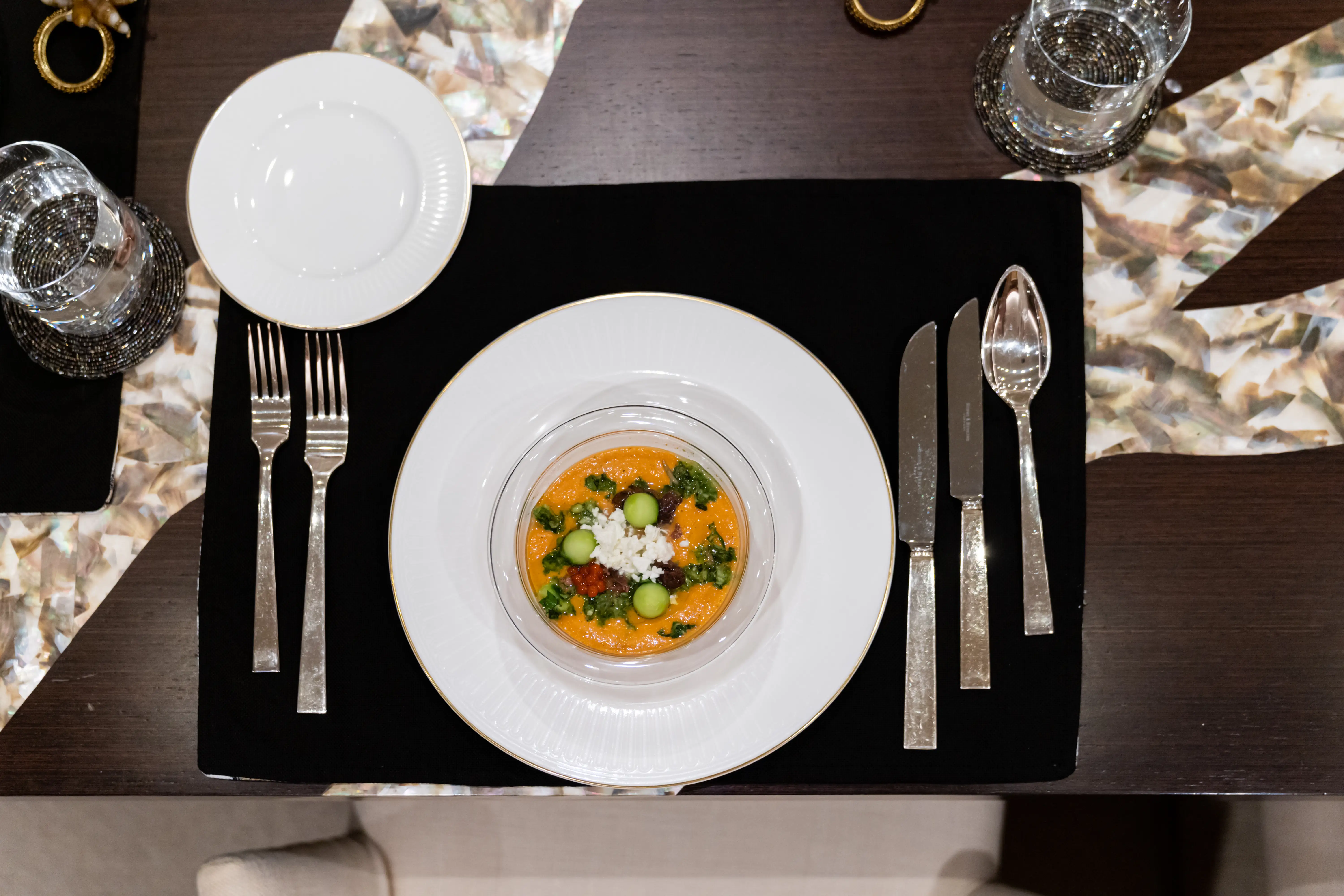 gazpacho in dish next to silverware on placemat