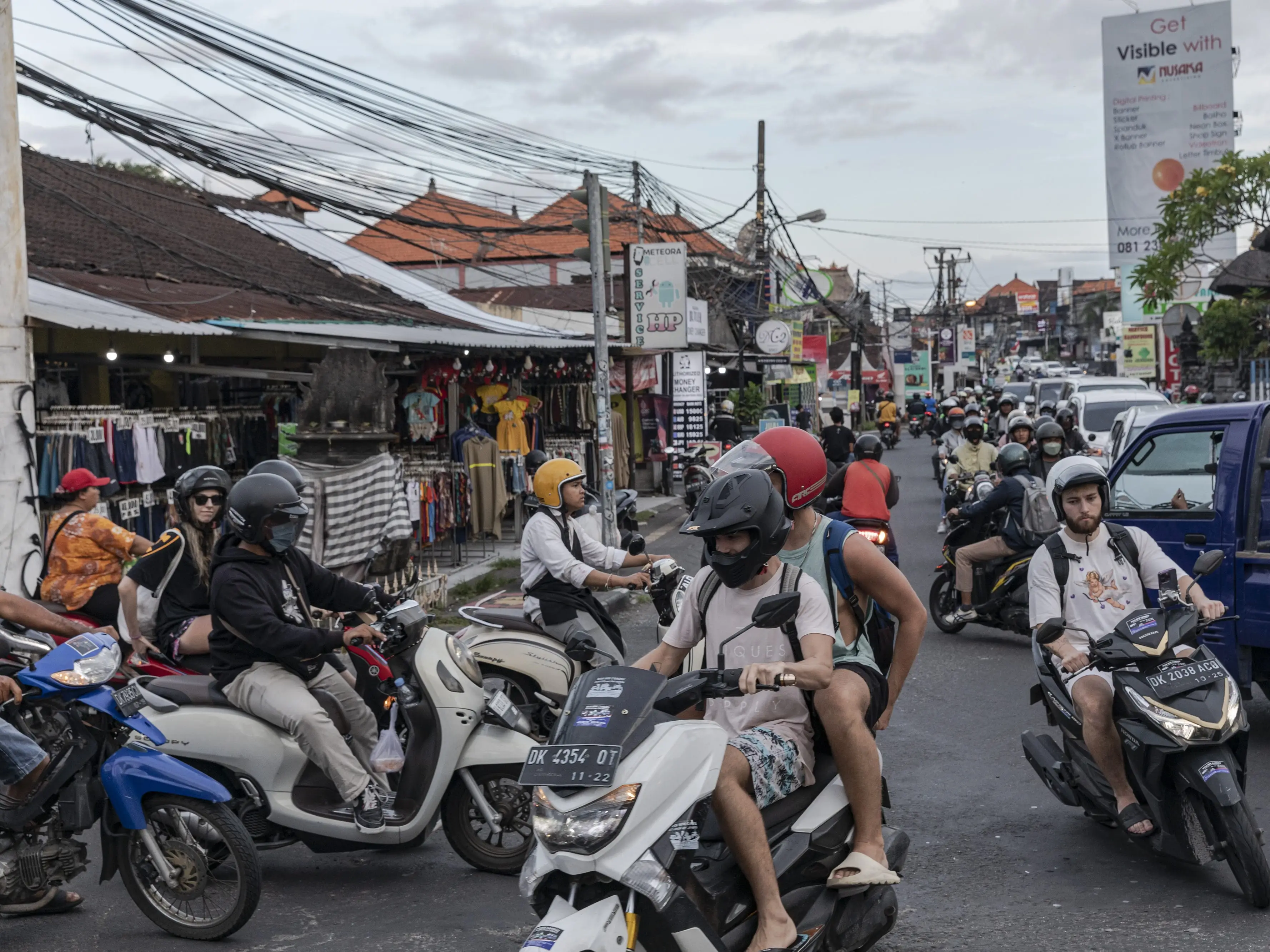Motorcyclists travel on a street in Canggu, Bali, Indonesia.