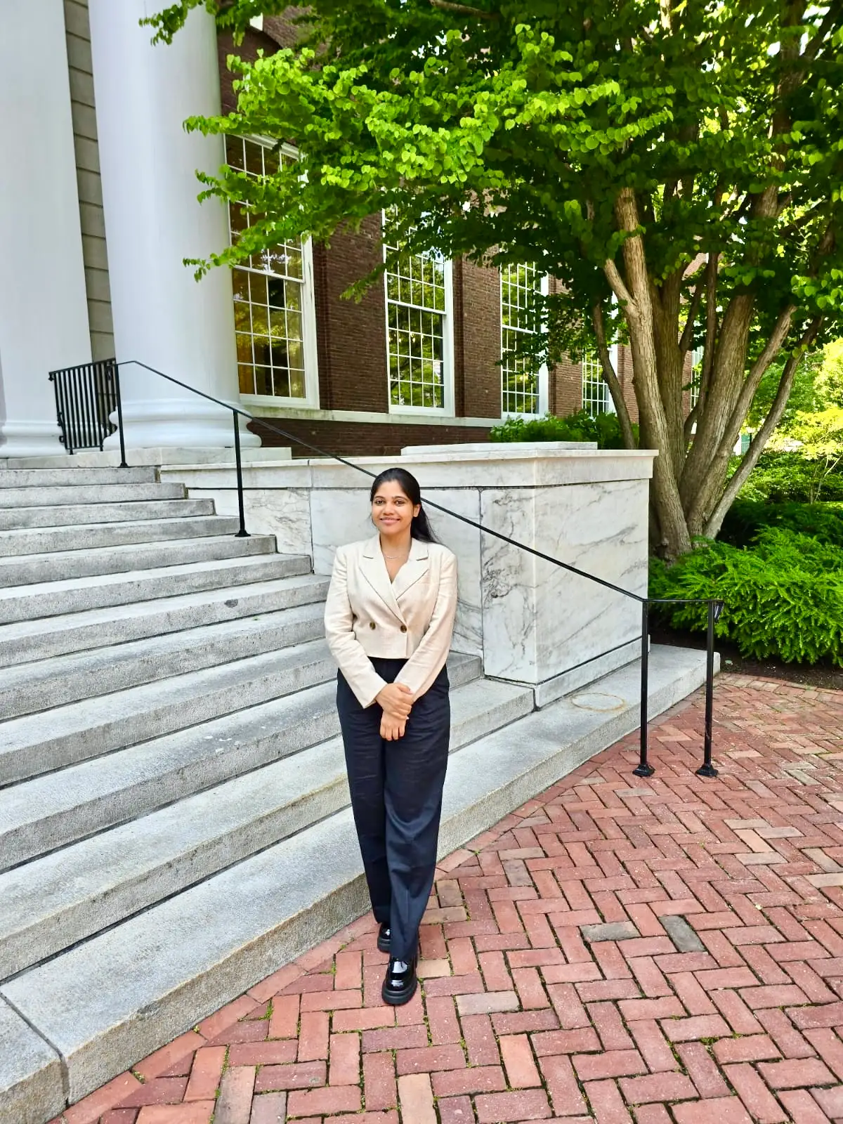 Shreya Mishra Reddy is wearing black trousers and a white blazer.