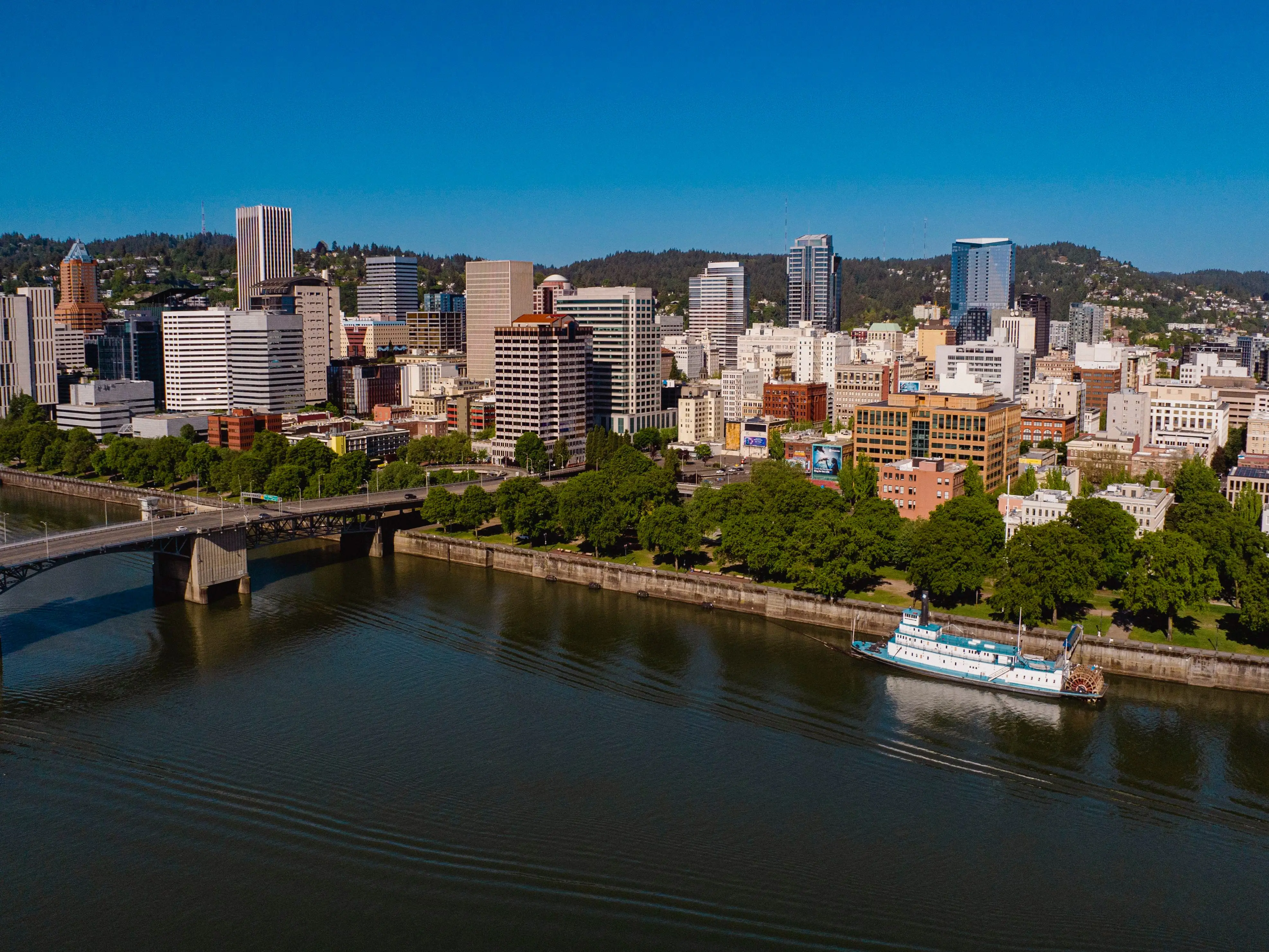 An aerial image of a city with a river in the forefront.