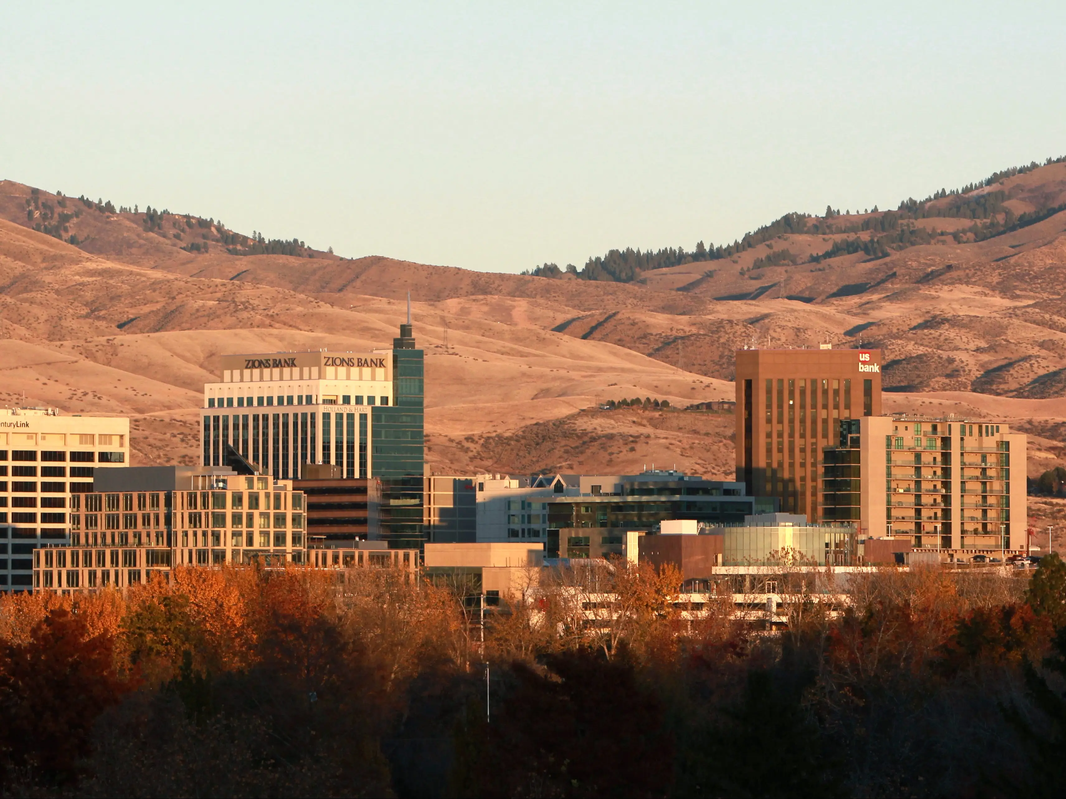 A city skyline with brown mountains in the background.