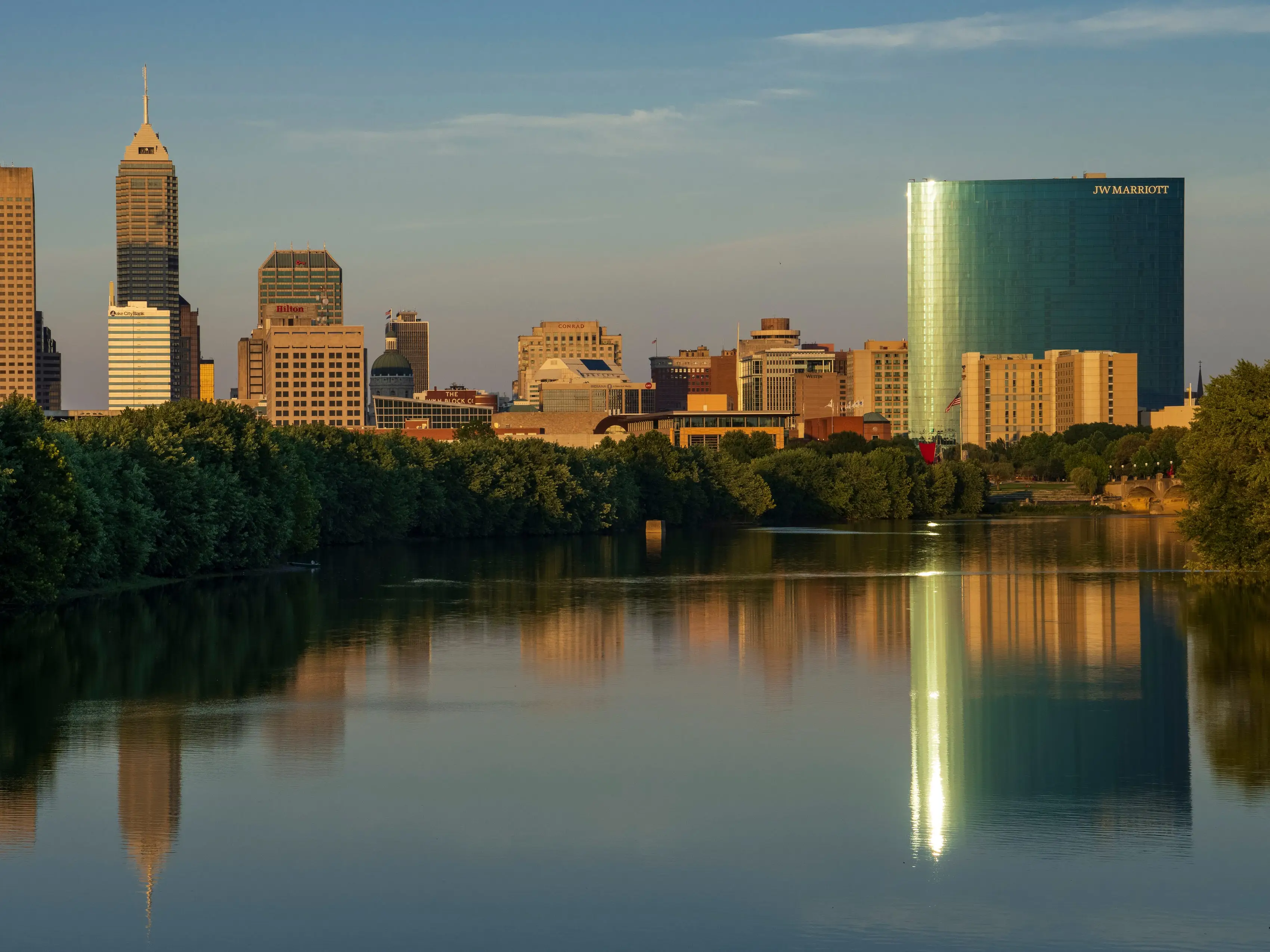 A view of a city skyline with a river at the foreground.