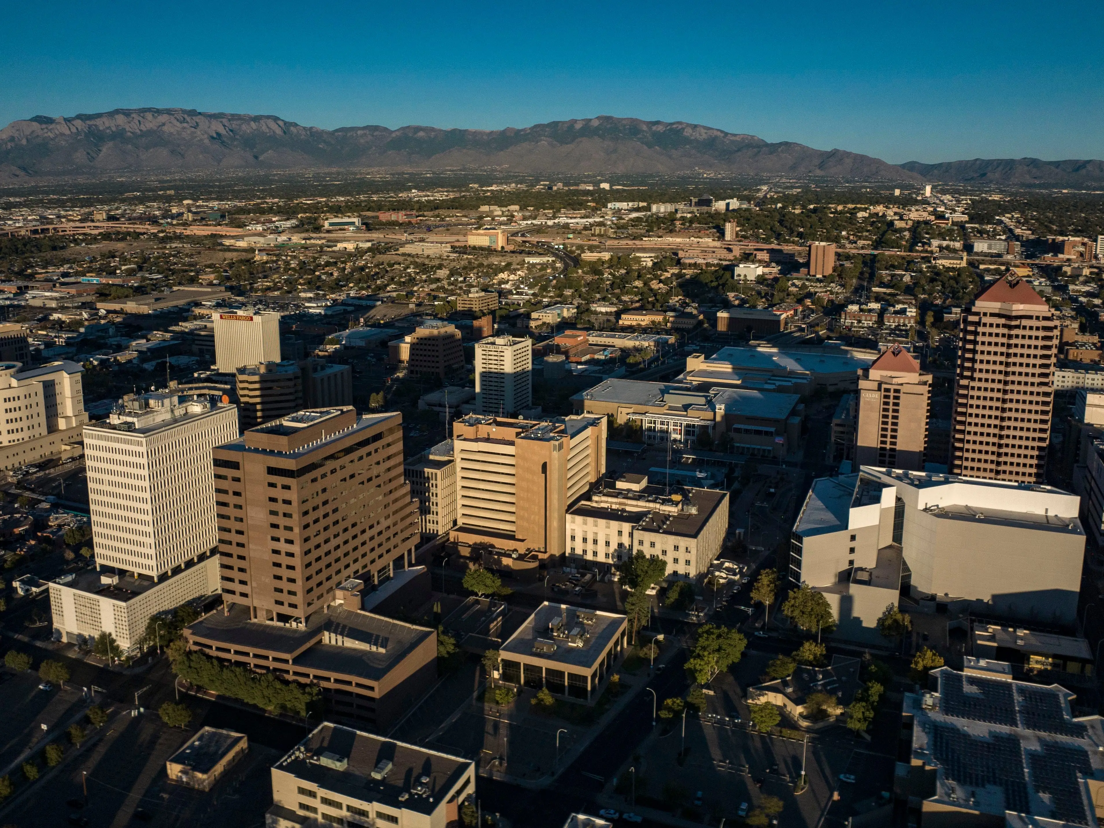 An aerial photo of a city with mountains in the background.
