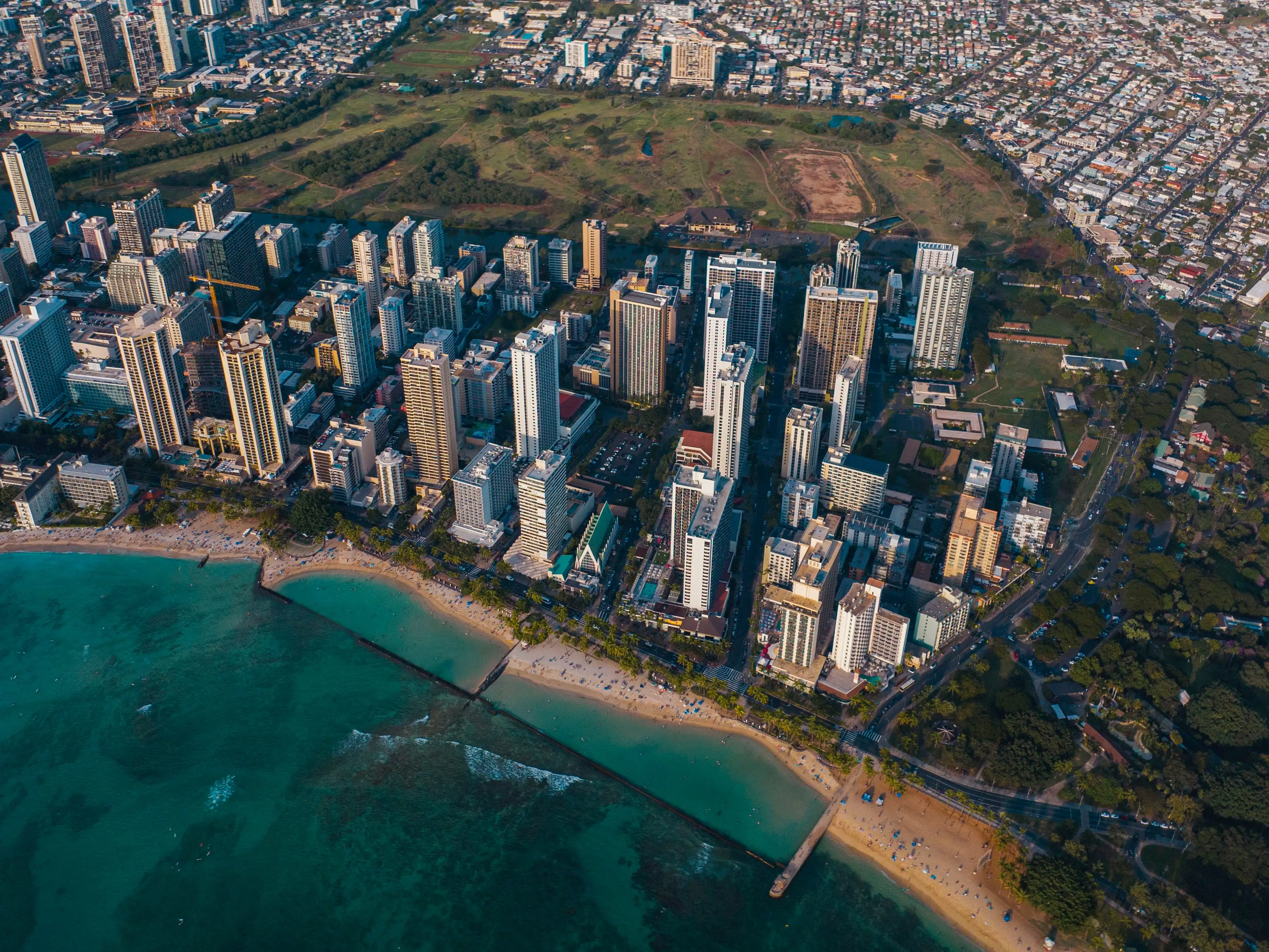 An aerial view of a city with the ocean next to it.