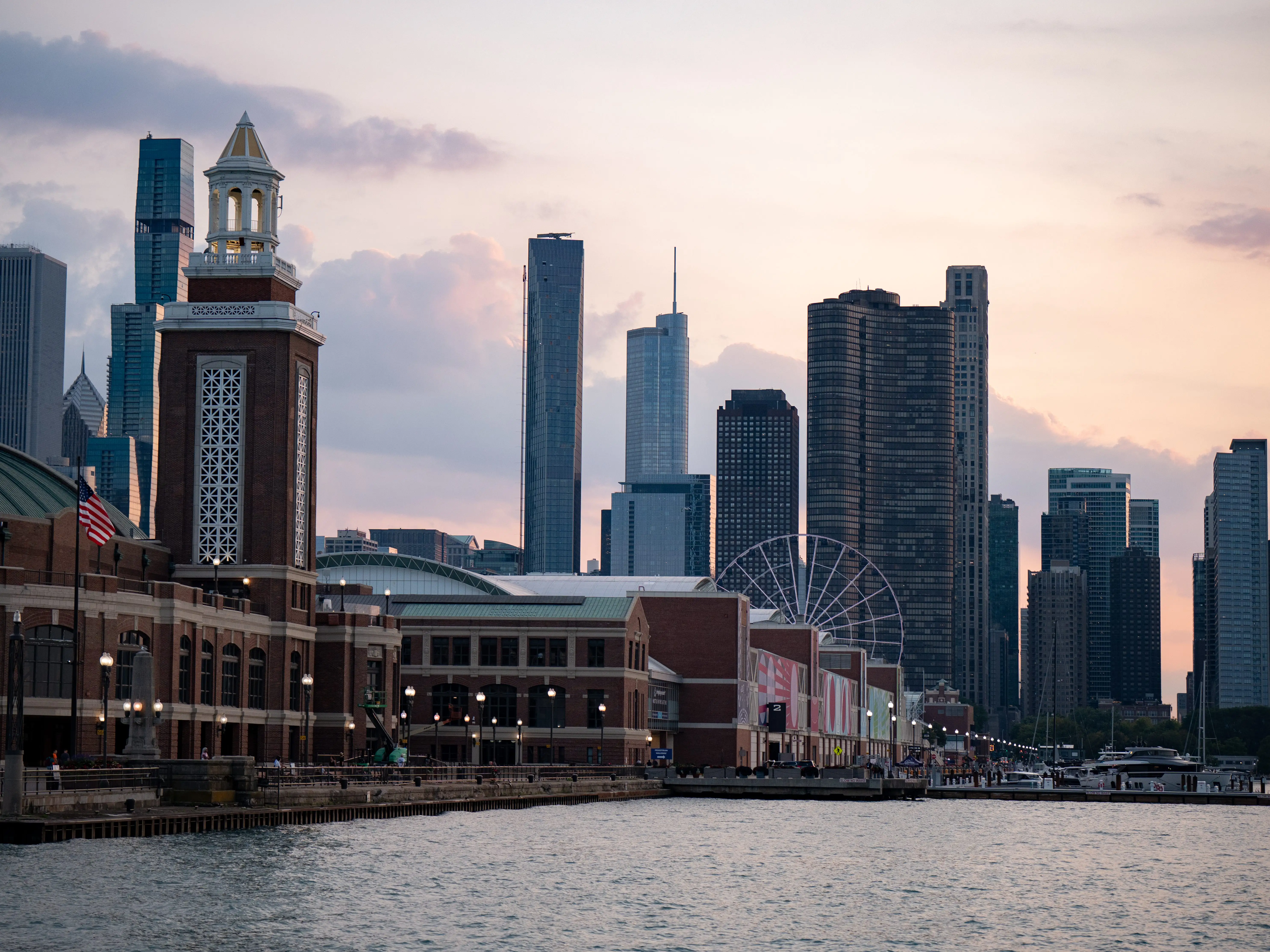 A photo of a city skyline at sunset with a body of water in the foreground.