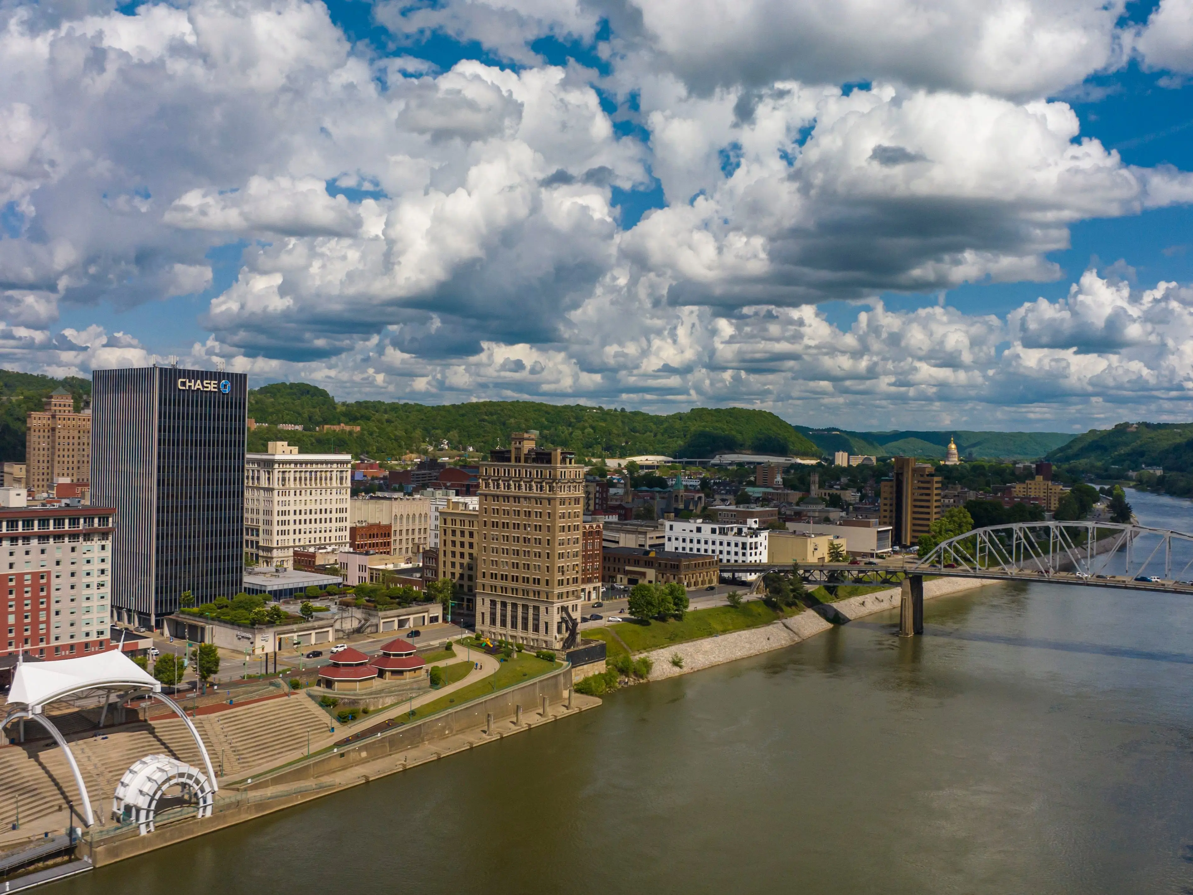 An aerial image of a city with a river and bridge in the foreground.
