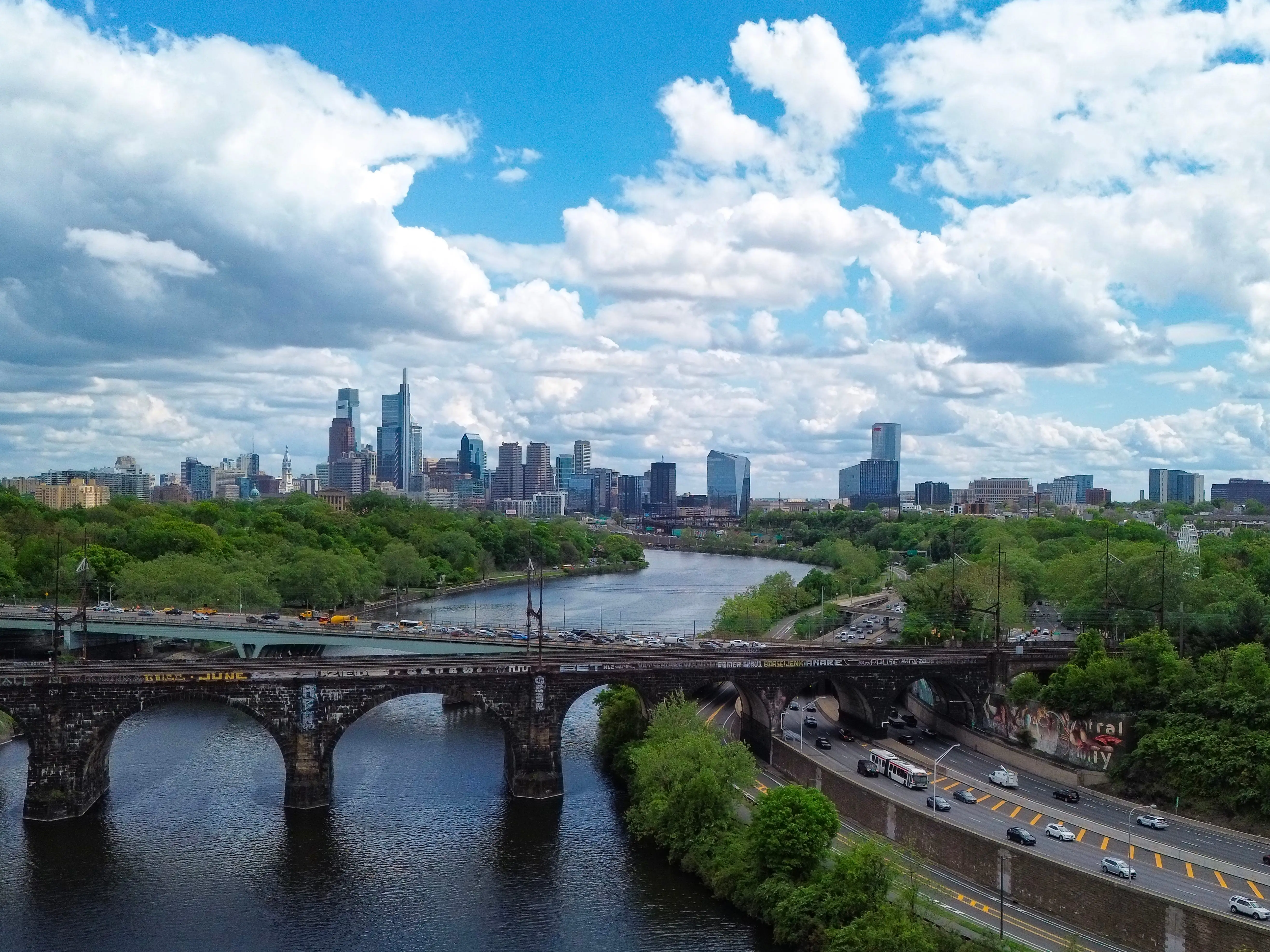 An image of a city with a bridge and river in the foreground.