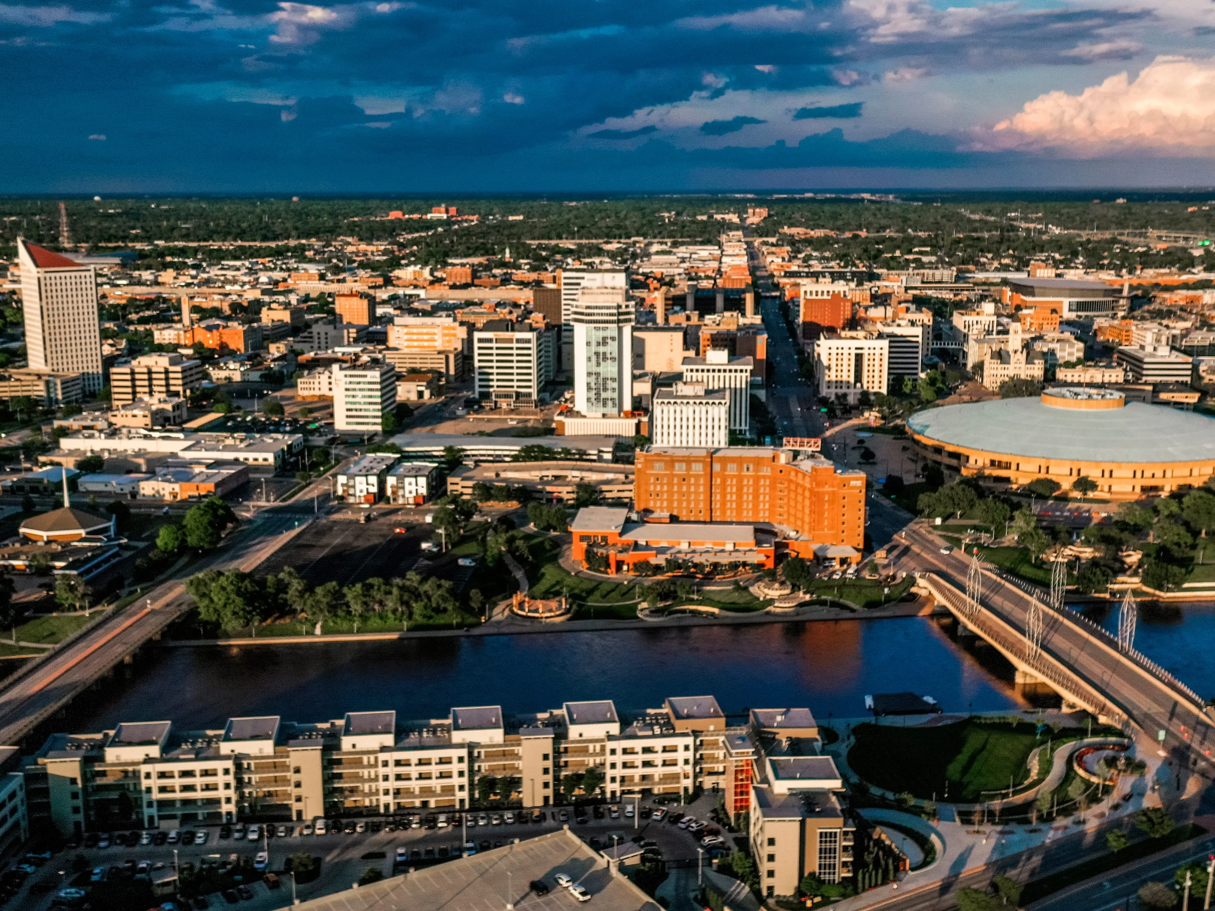 An aerial shot of a city at sunset, with thunderclouds in the background.