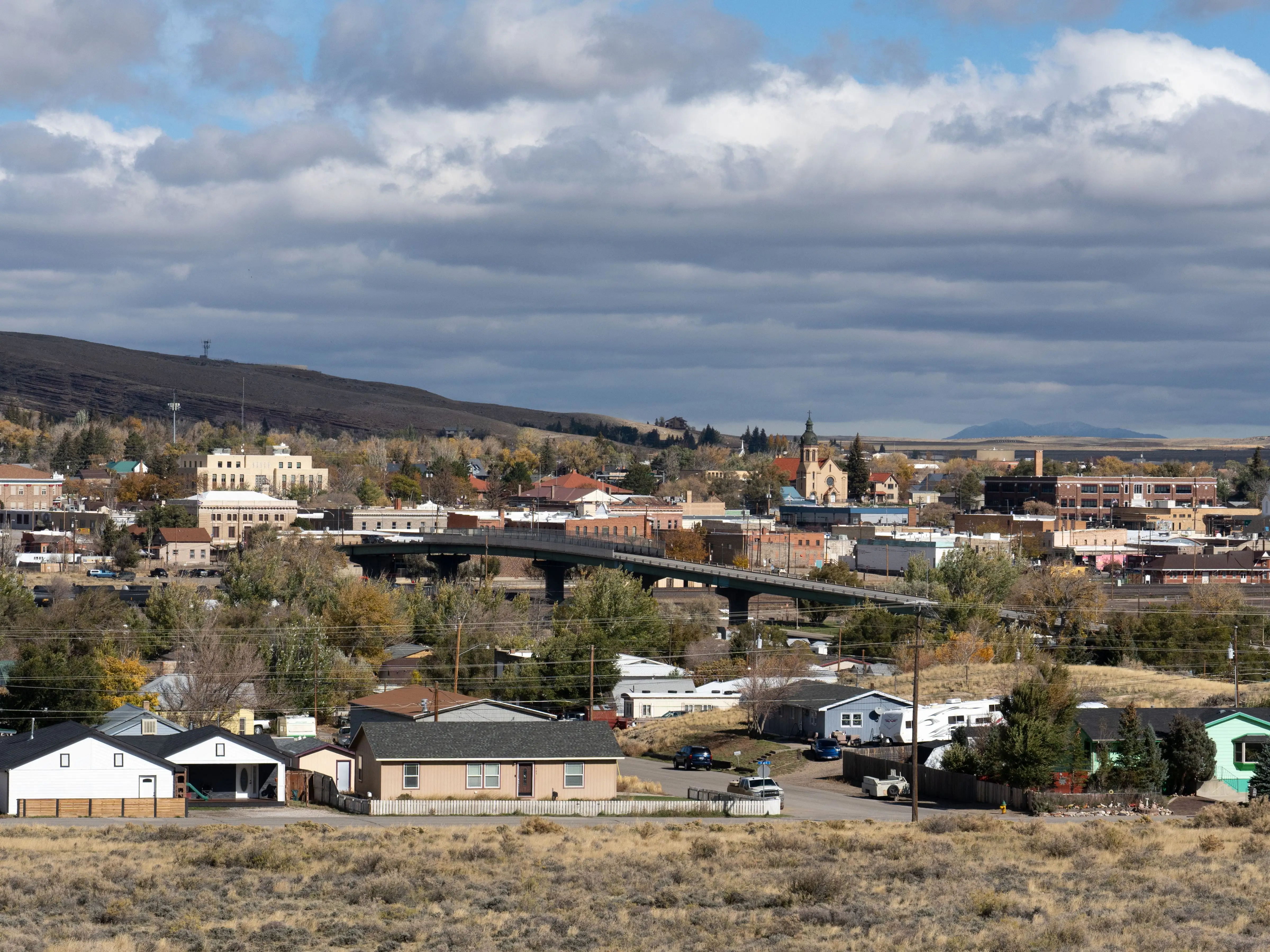 A photo of a populated Midwest town with a small mountain in the background.