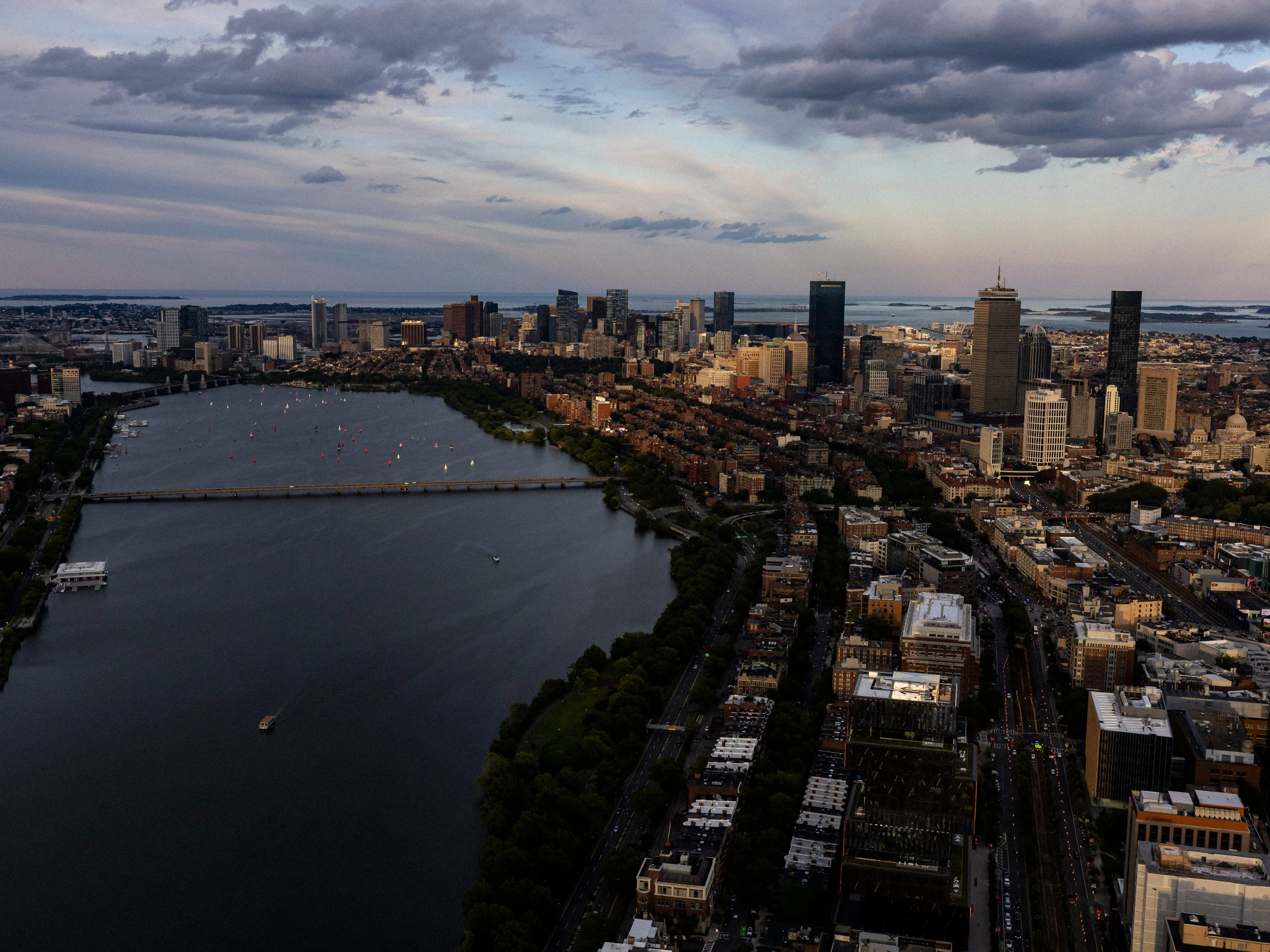 An aerial photo of a city at dusk with a river separating the two sides of the city.