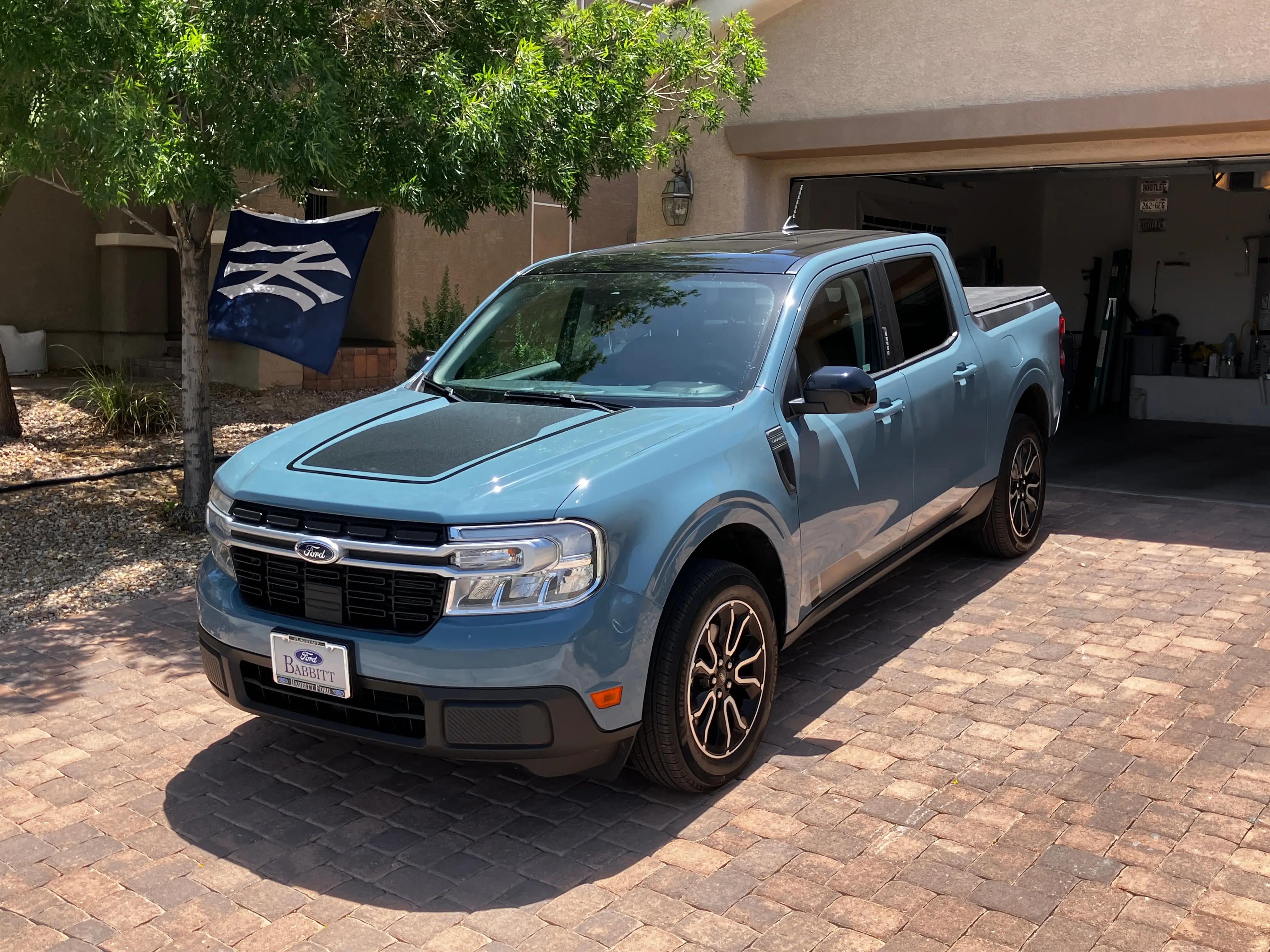 A Ford Maverick Hybrid truck is parked in a driveway.
