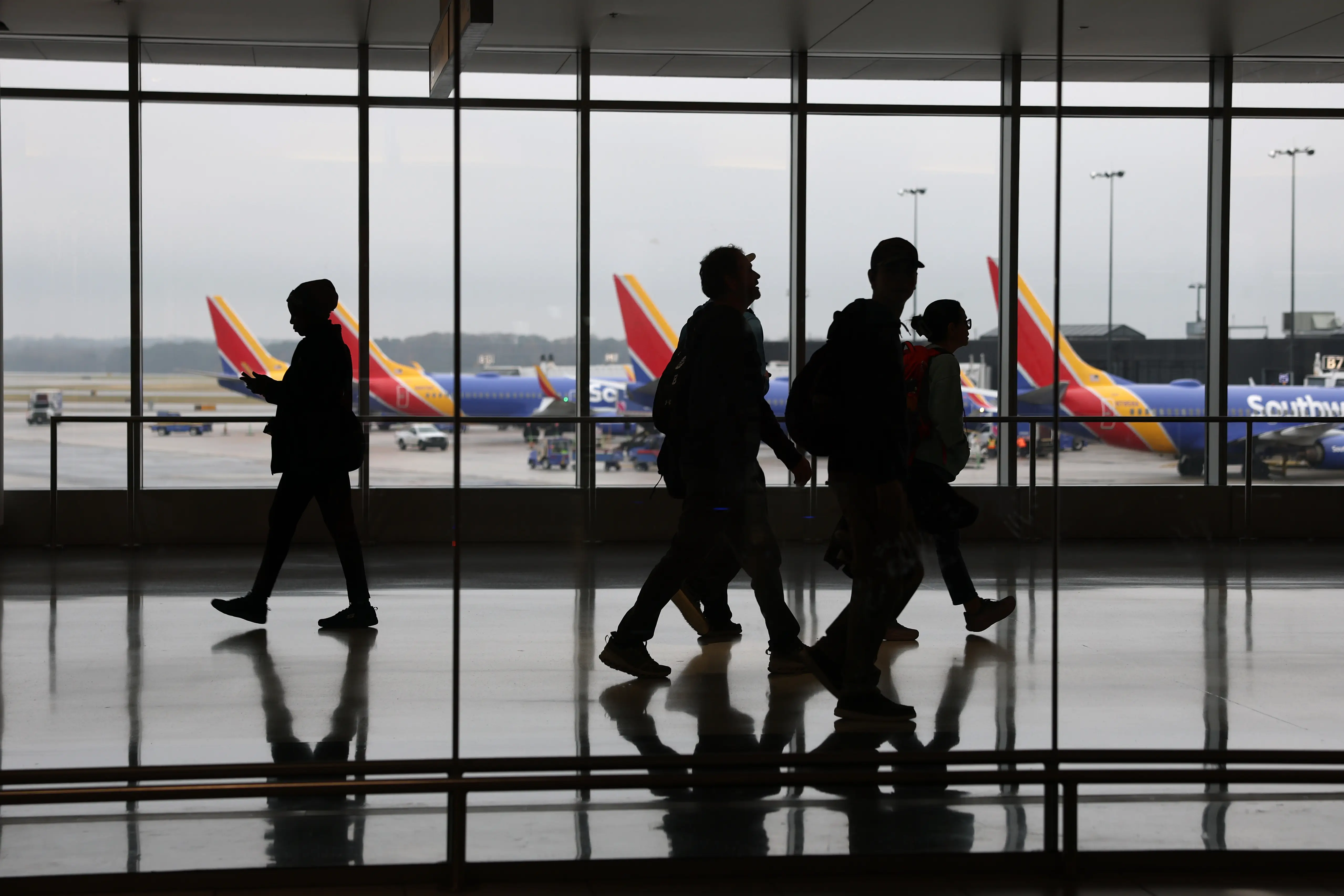 Travelers walk by airplanes with Southwest Airlines on the tarmac at the Baltimore/Washington International Thurgood Marshall Airport
