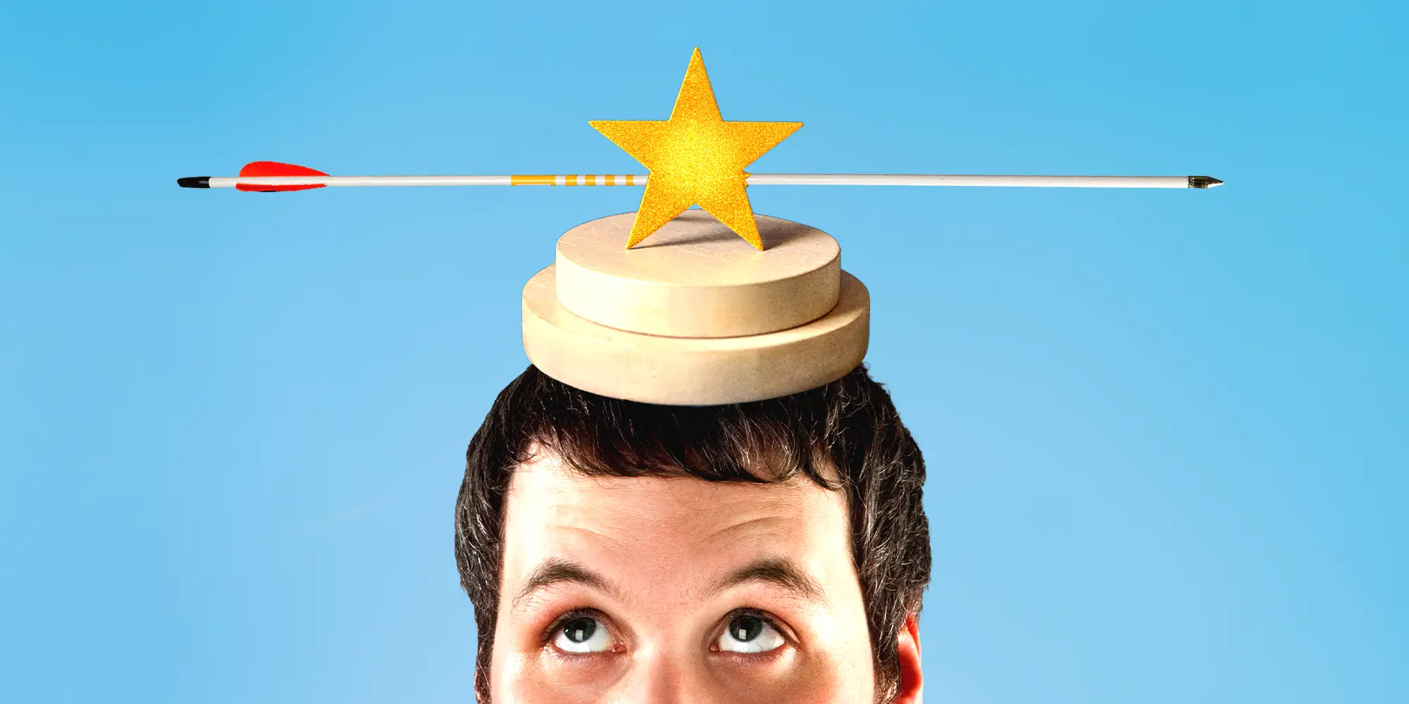 A person balances a wooden disk topped with a yellow-gold star, an arrow piercing it.