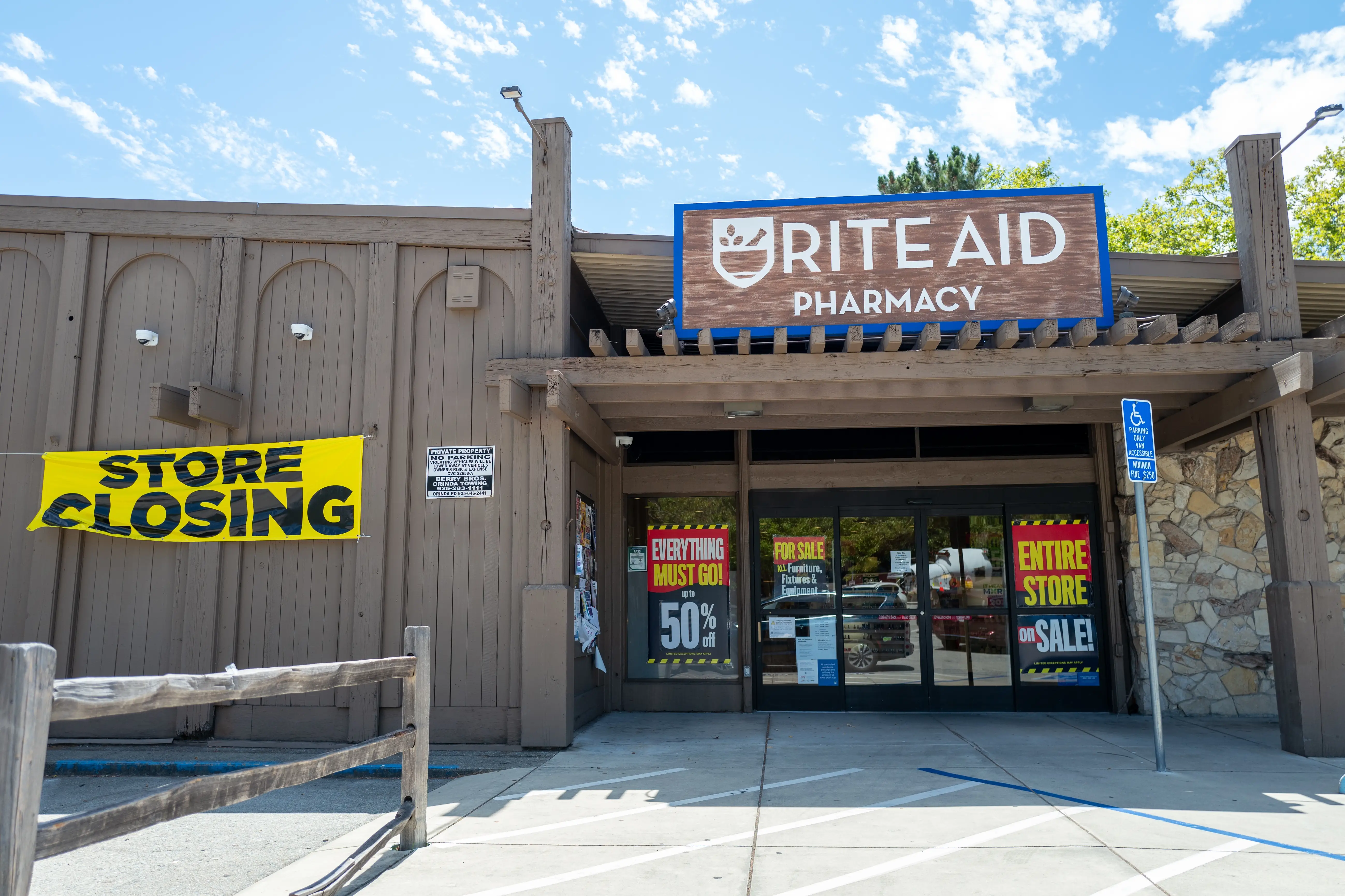 Store closing signs are visible on the facade of a Rite-Aid pharmacy and convenience store in Orinda, California.