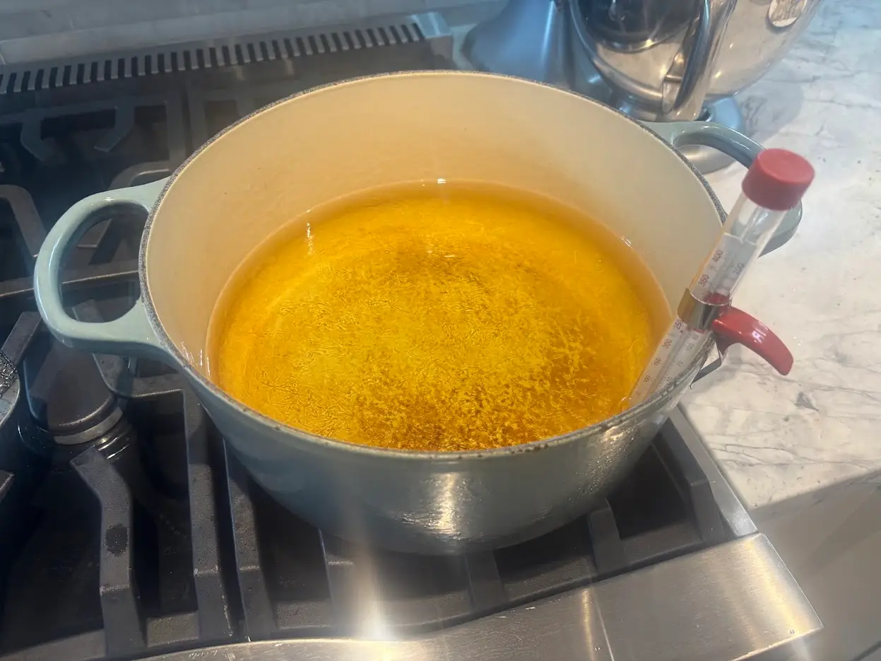 Canola oil being heated up in a Dutch oven.