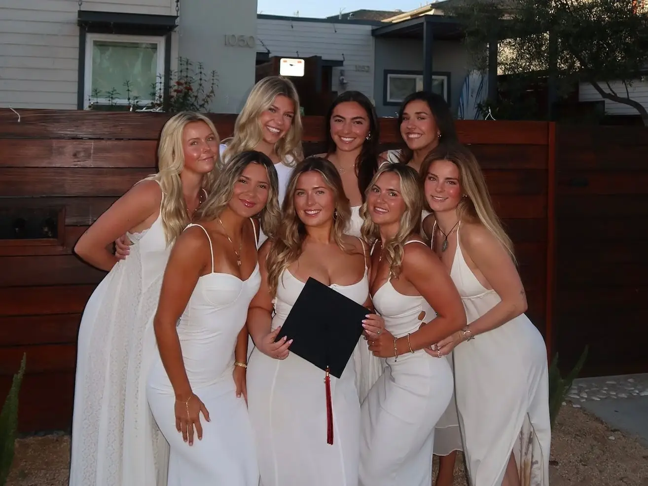 The writer and her seven roommates pose in front of their Pacific Beach, California, home before taking college graduation photos.