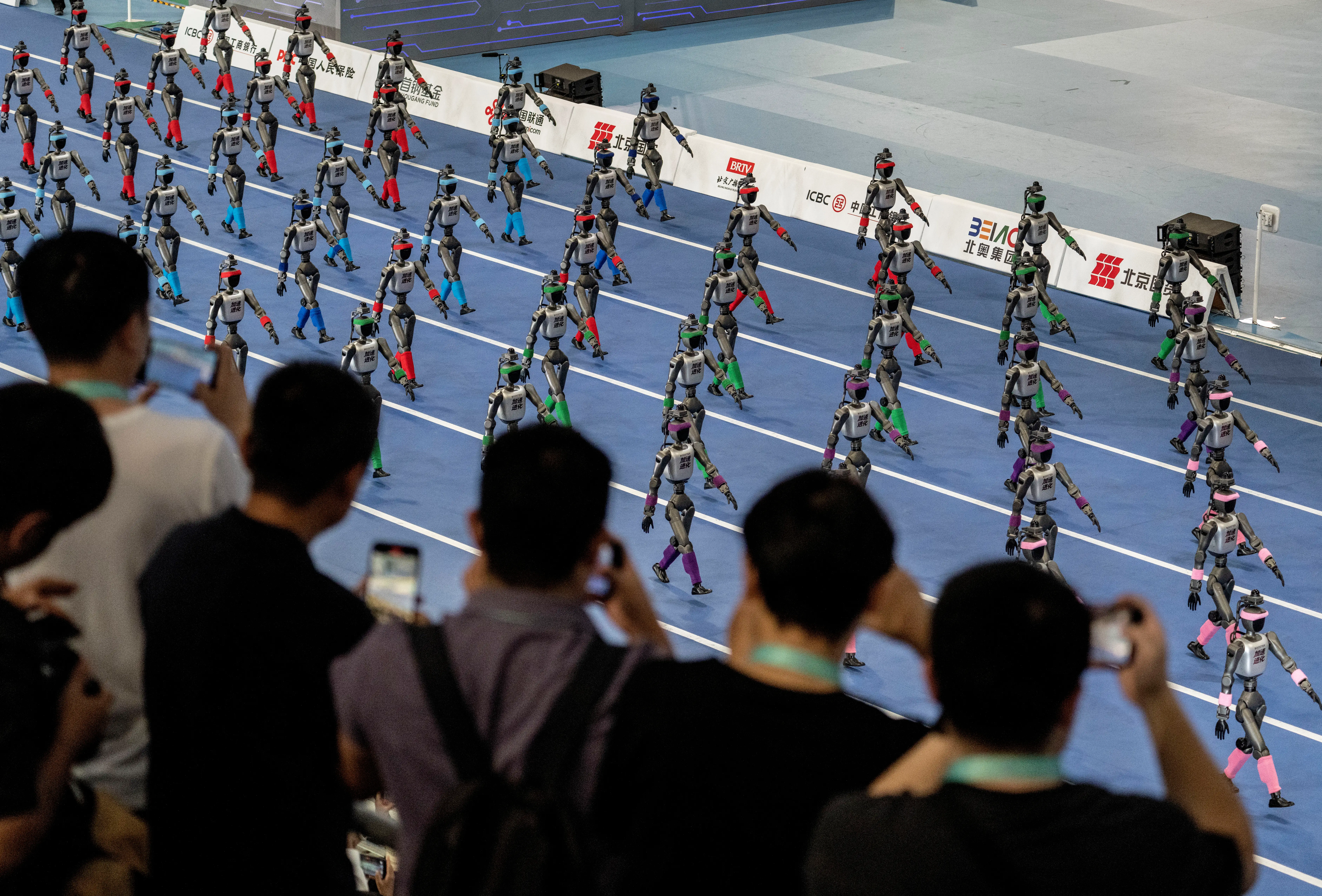 Humanoid robots parade down a track