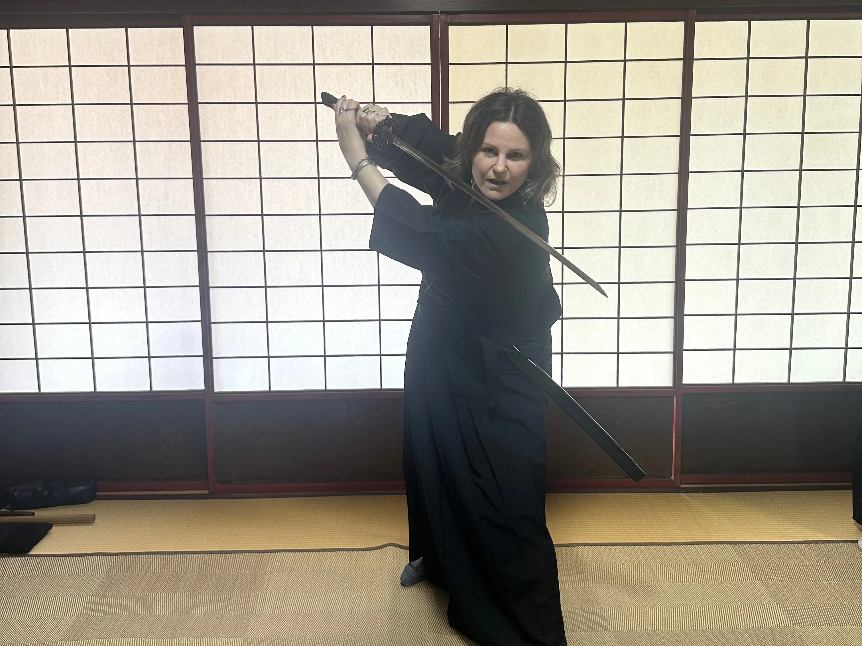 A foreigner holding a sort, standing on tatami mats in Japan.