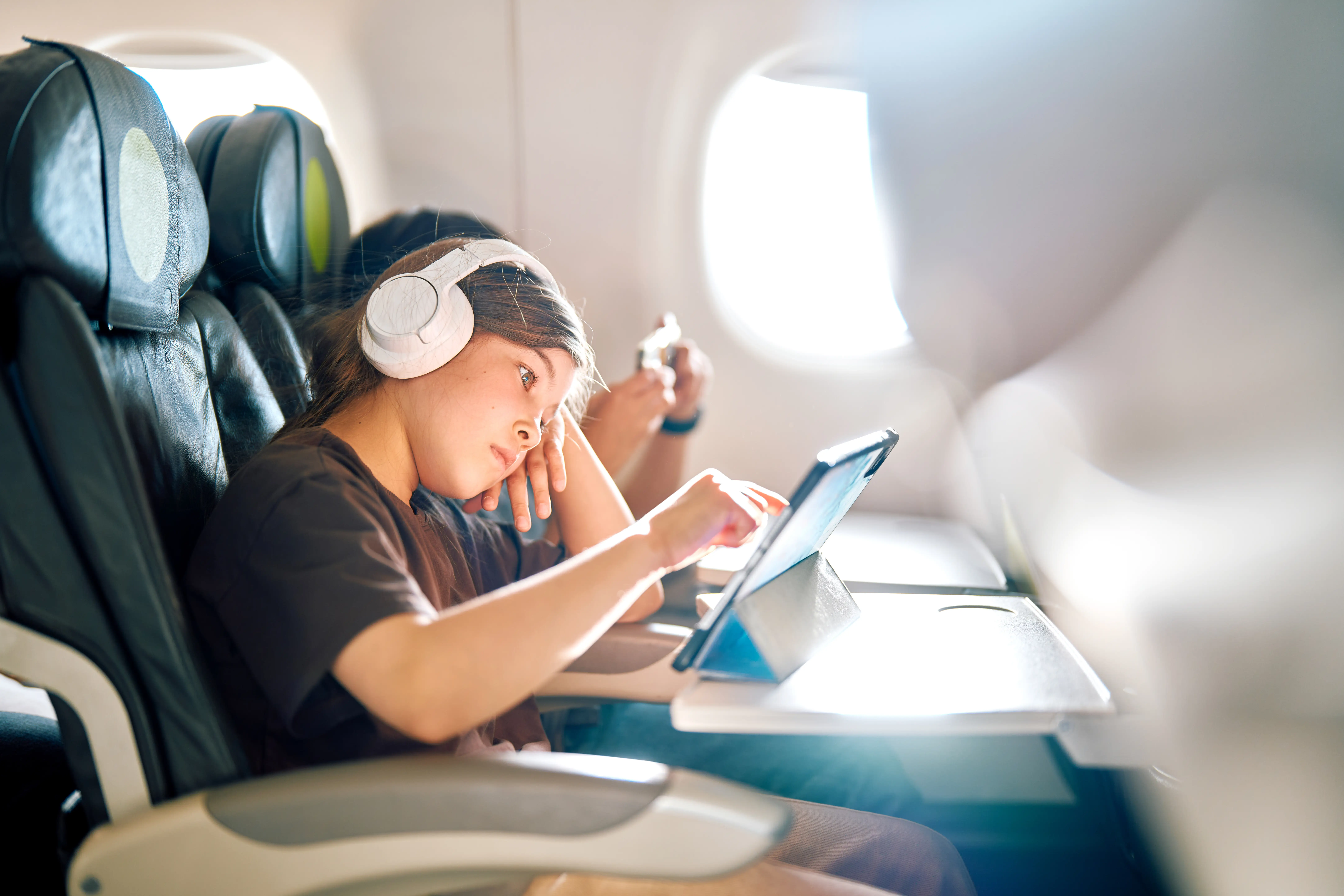 Child playng on ipad on plane.