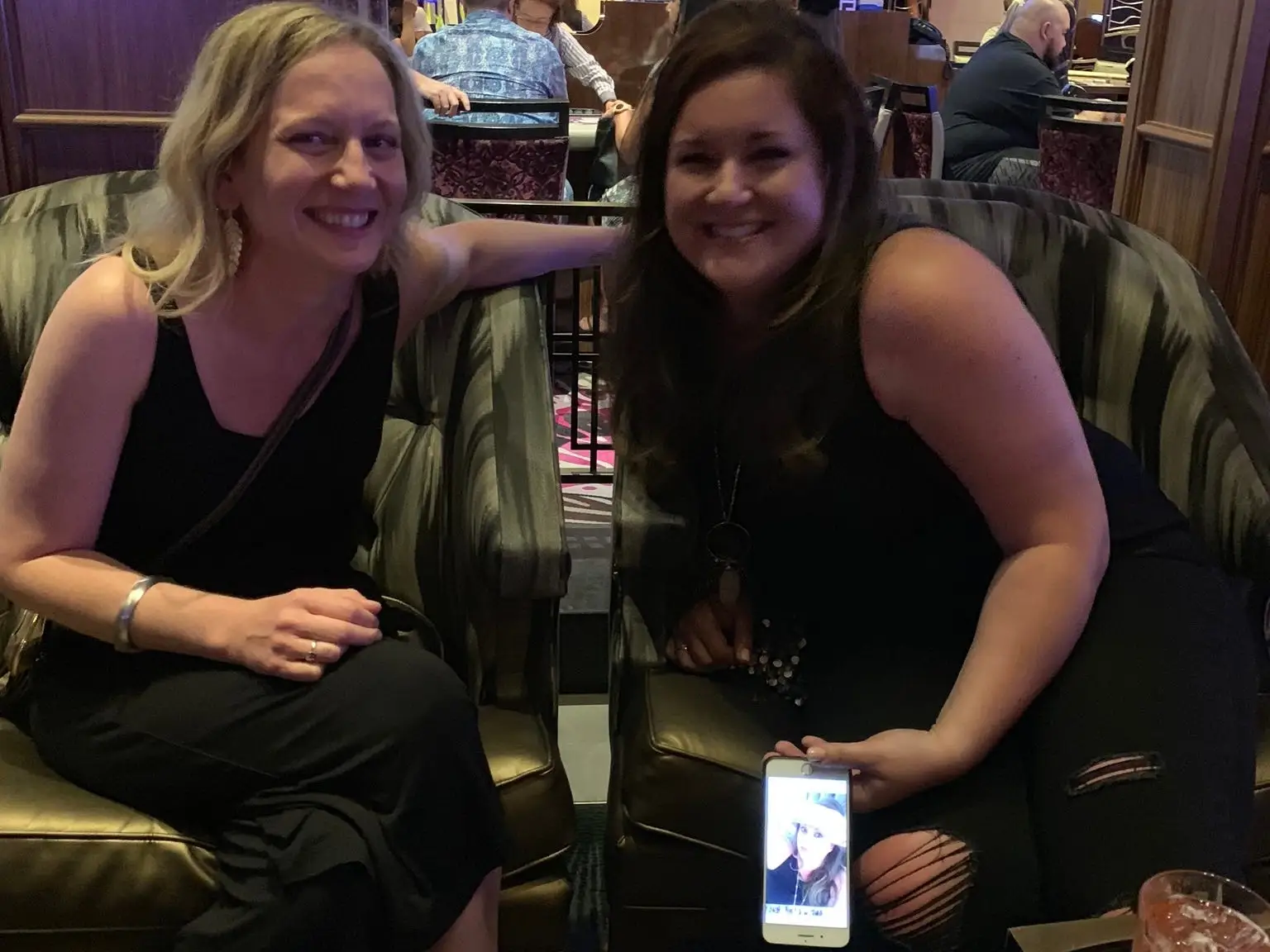 Two women smiling at a bar