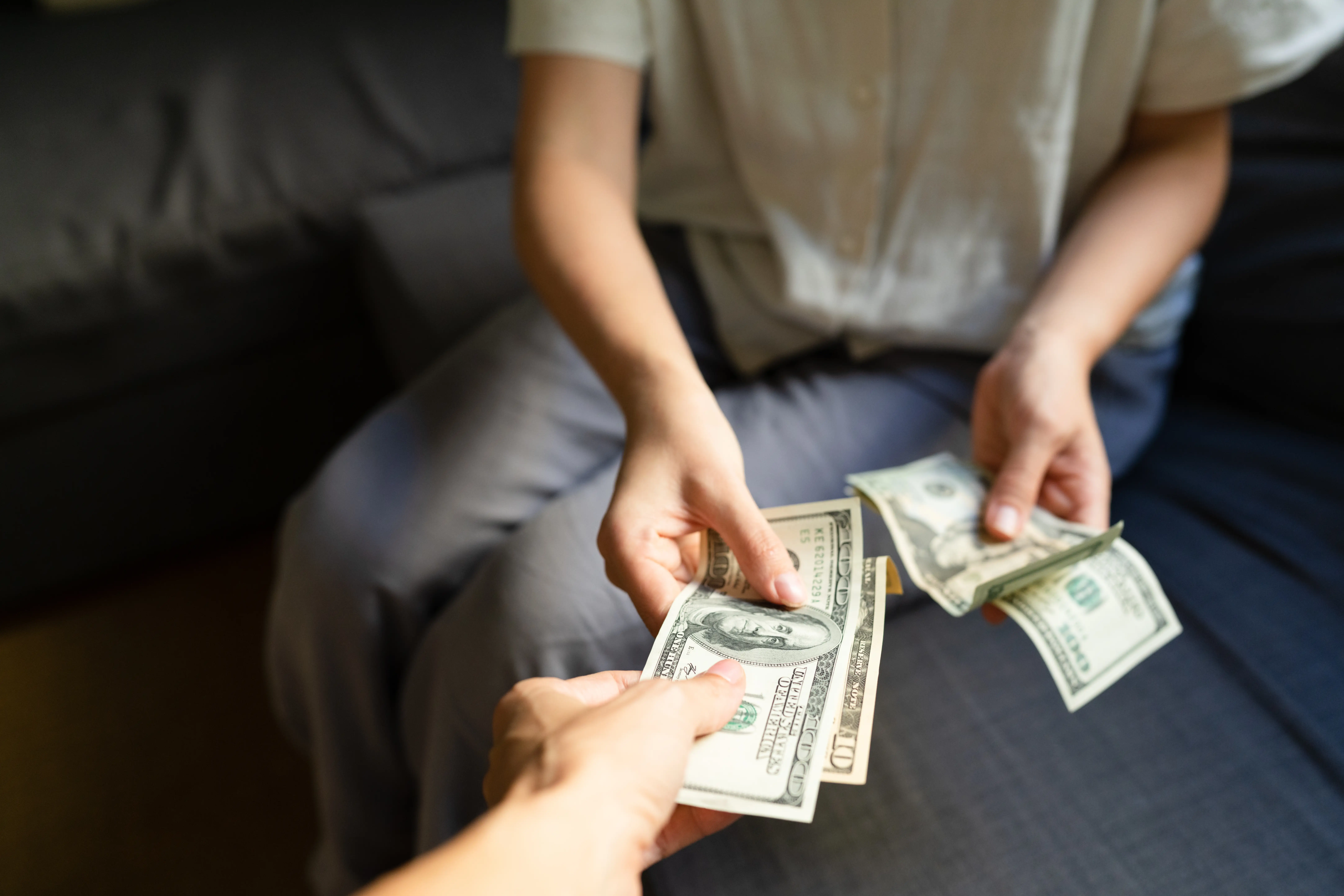 Close-up of a woman taking cash from another woman
