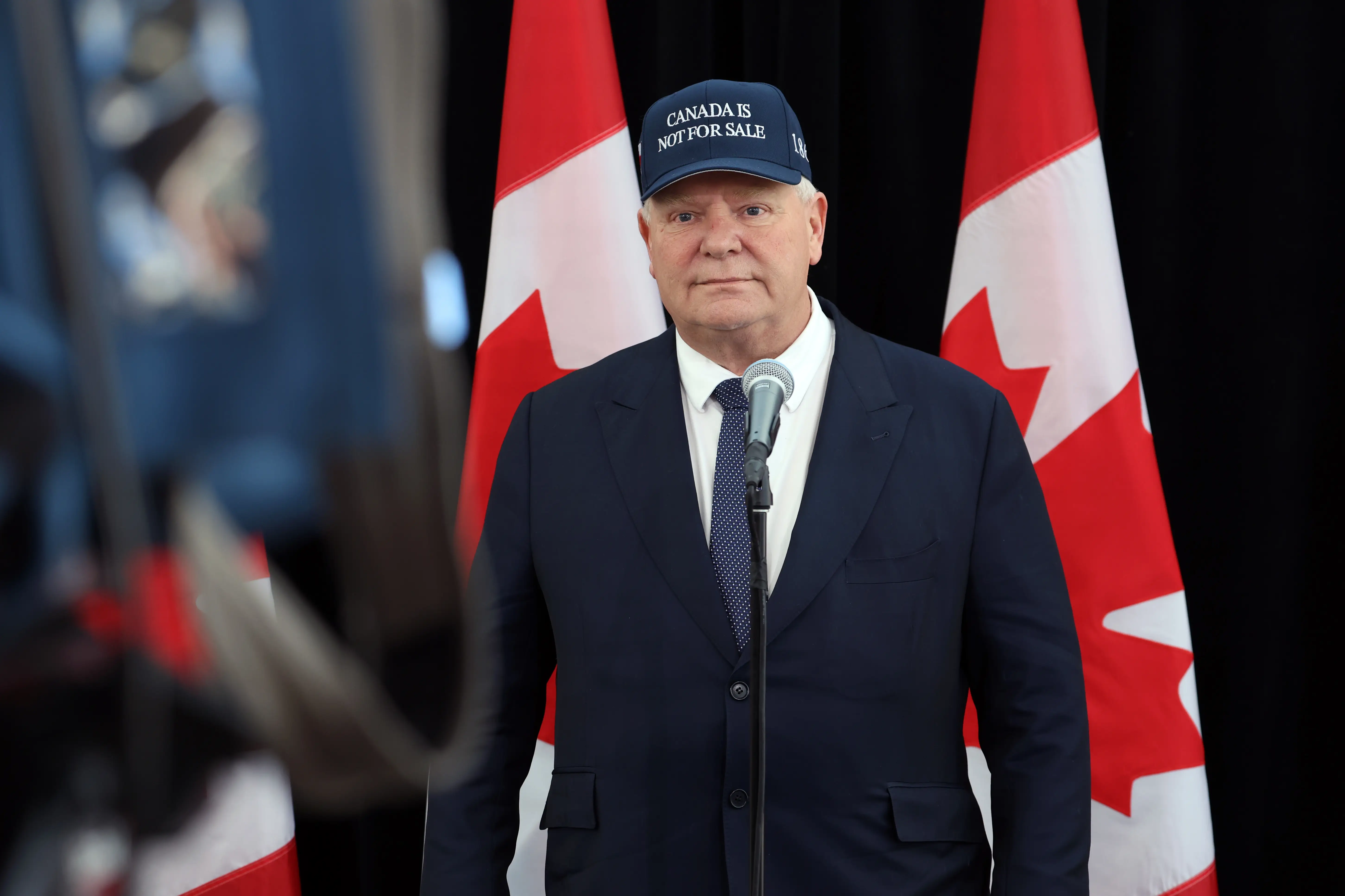 Doug Ford stands at a microphone wearing a