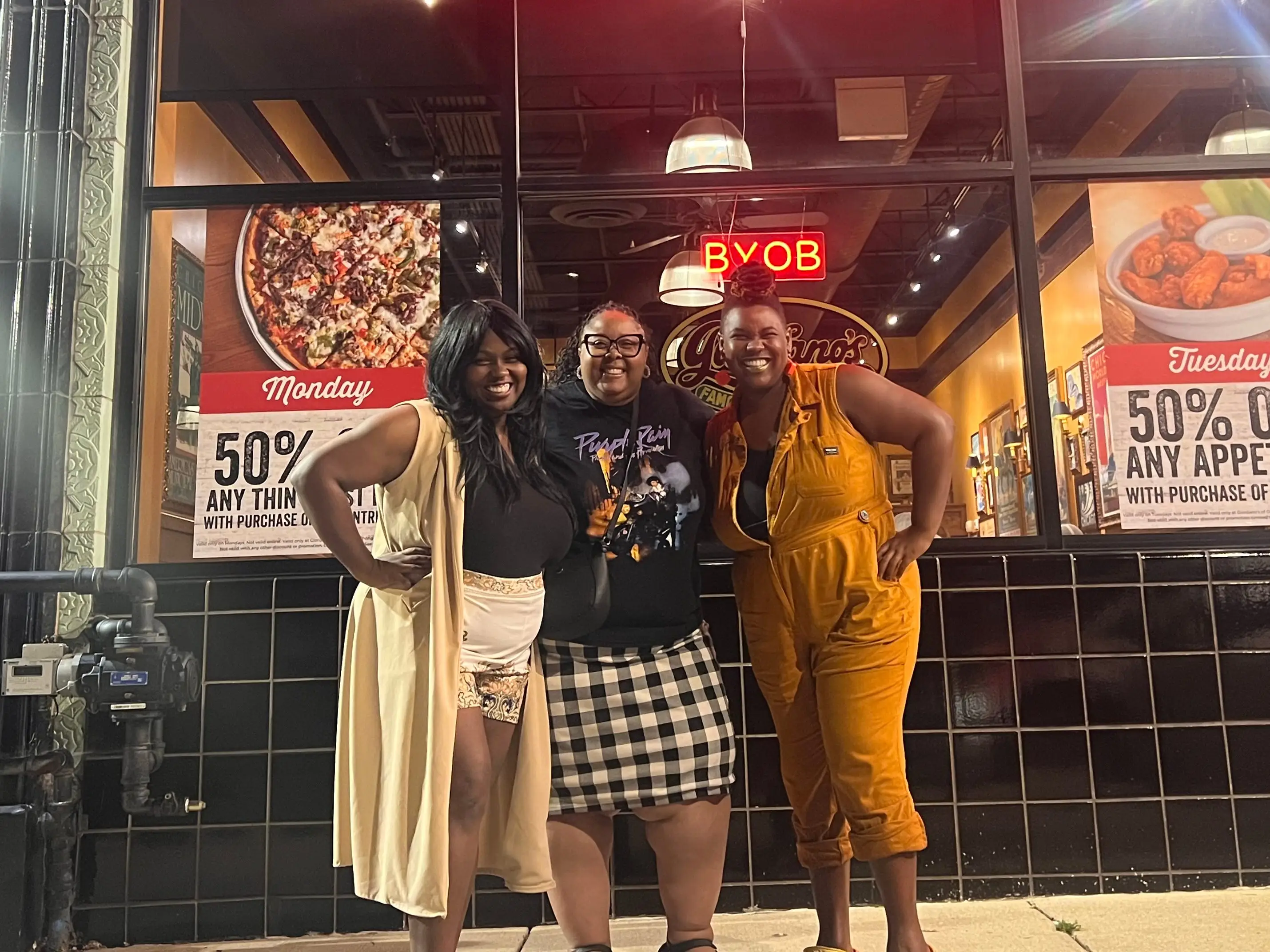 Renita and two friends pose for a photo outside a restaurant.