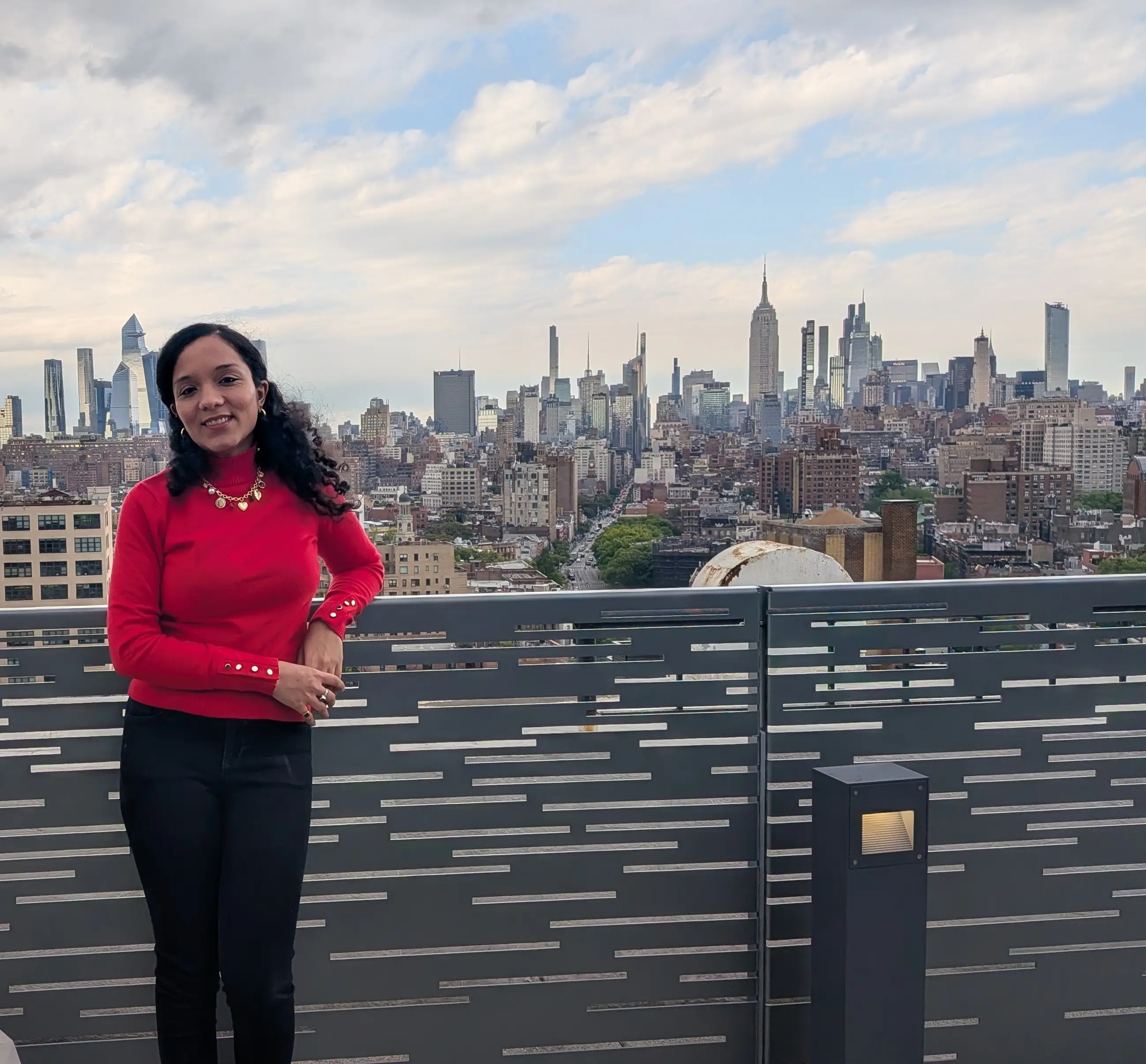 Disha Lamba is standing in front of the NYC skyline.