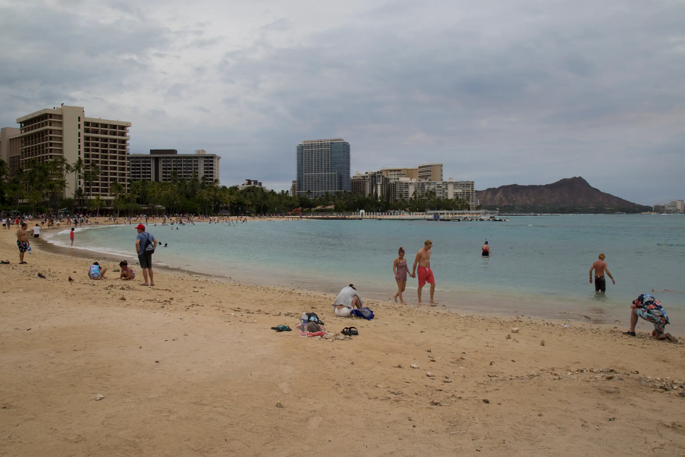 People walk on a Honolulu beach.