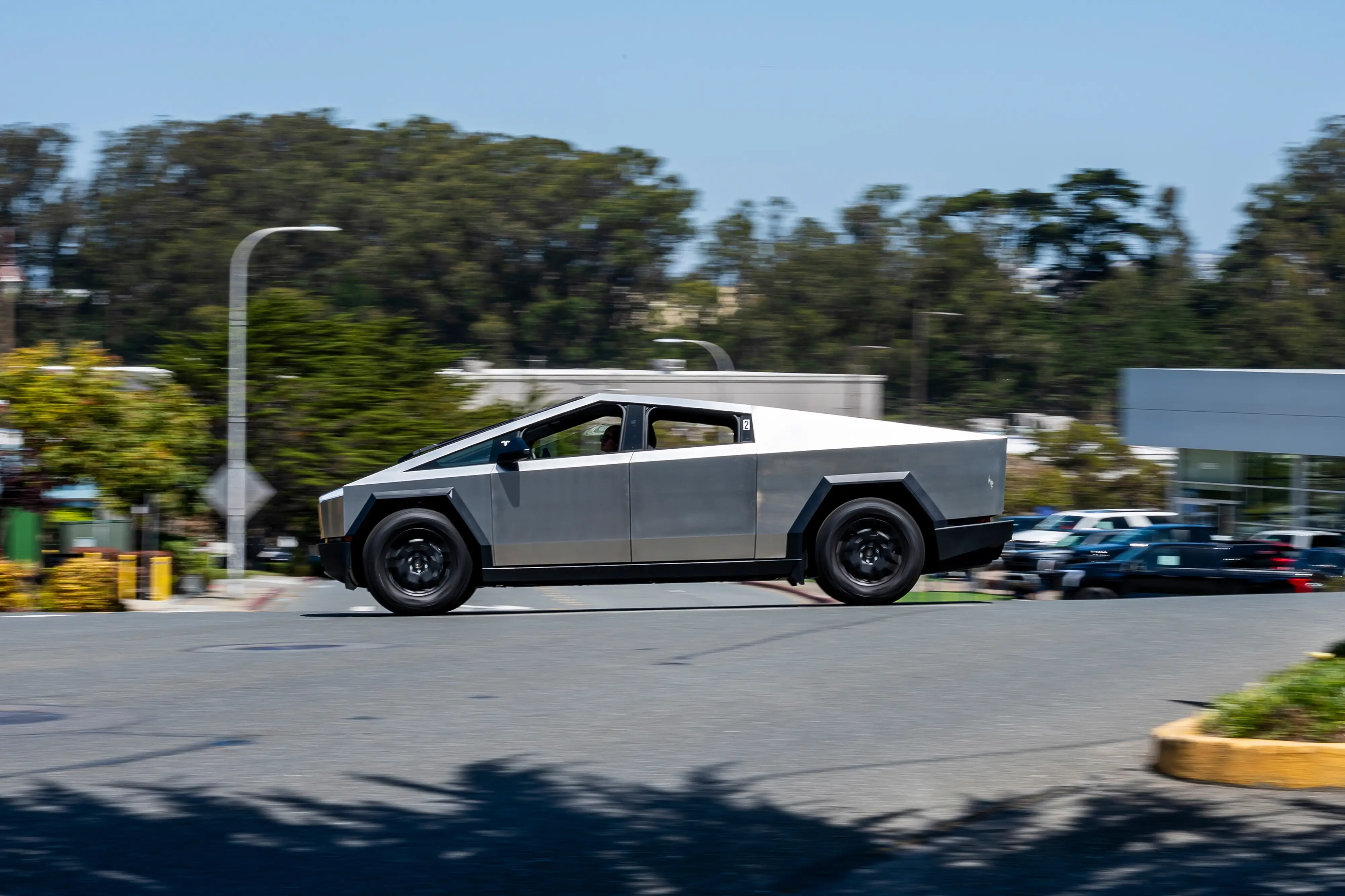 A Tesla Cybertruck drives down a road.