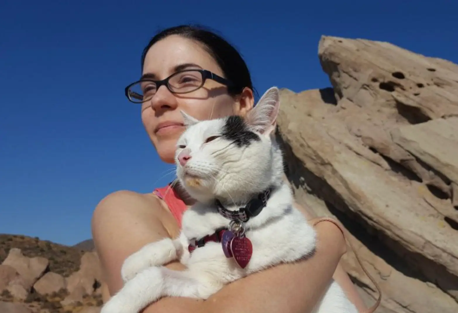 The writer hiking with her white cat.