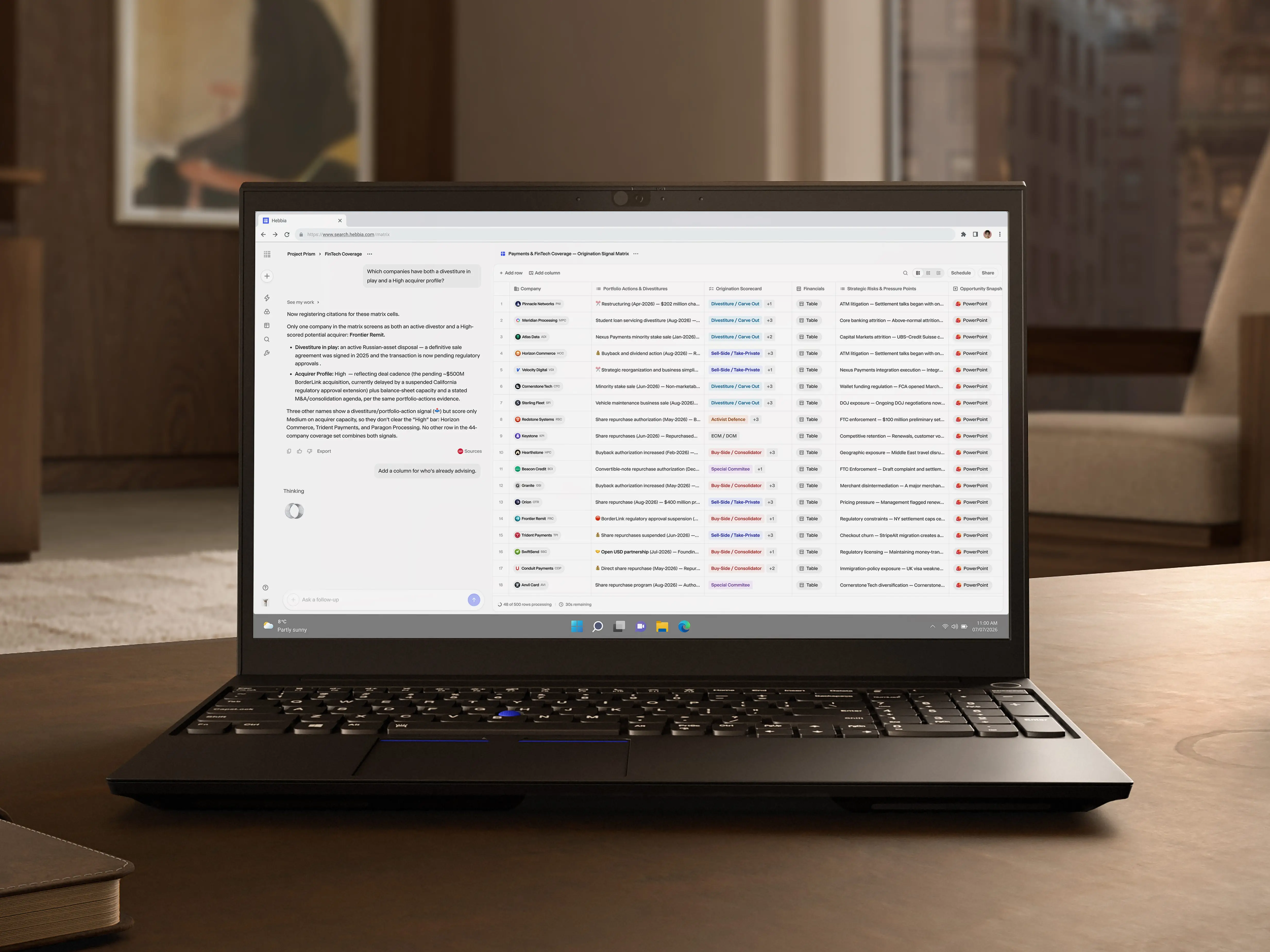 Laptop displaying a web dashboard sits on a wooden desk in a softly lit office.