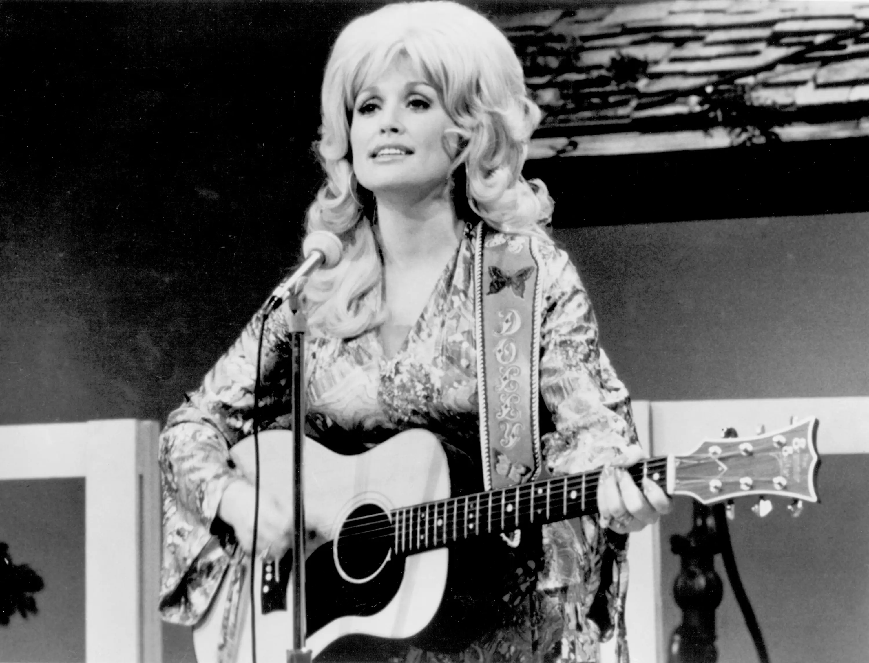 Dolly Parton performs with an acoustic guitar circa 1974.