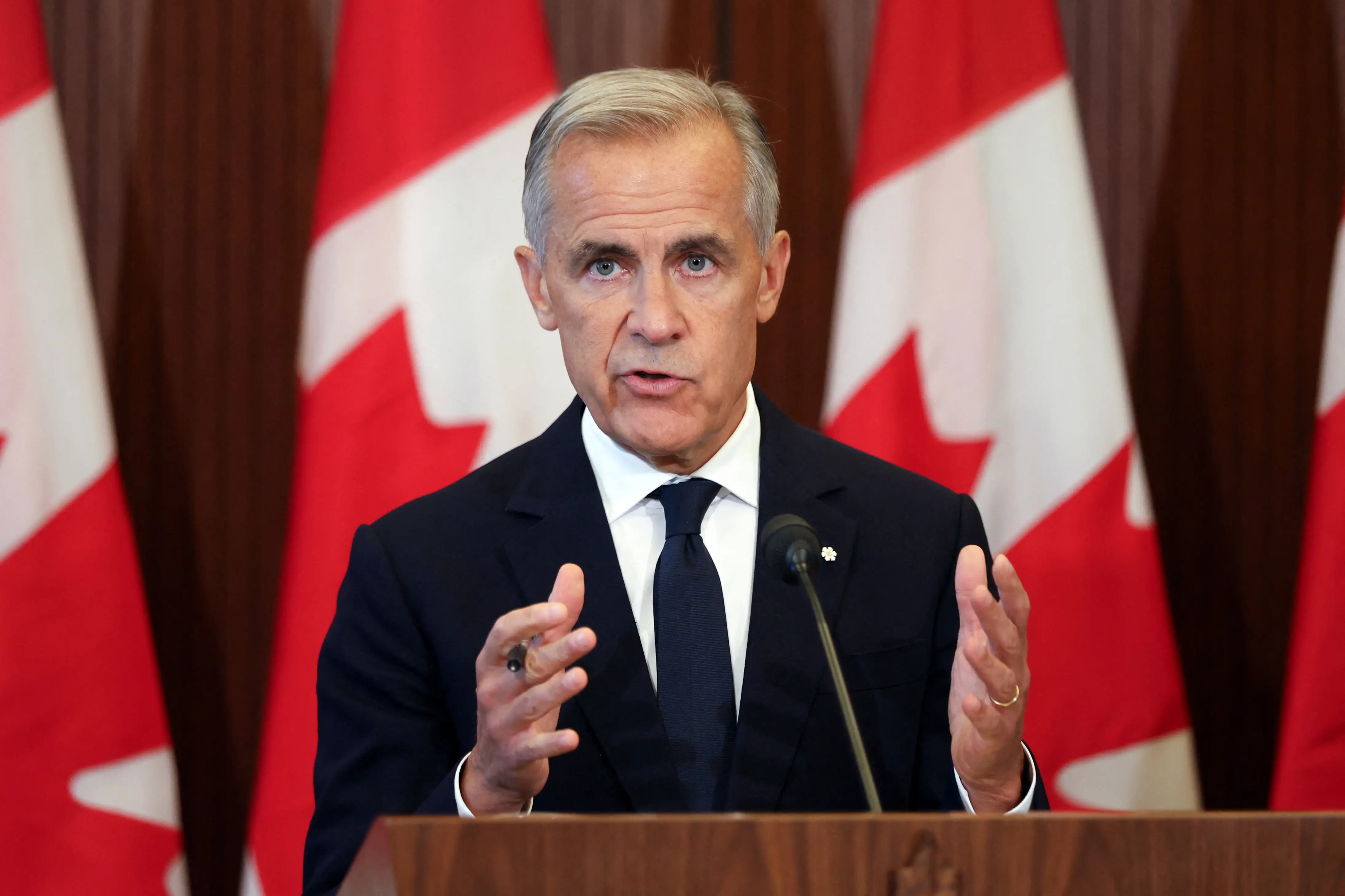 Canada PM Mark Carney speaks at a podium.
