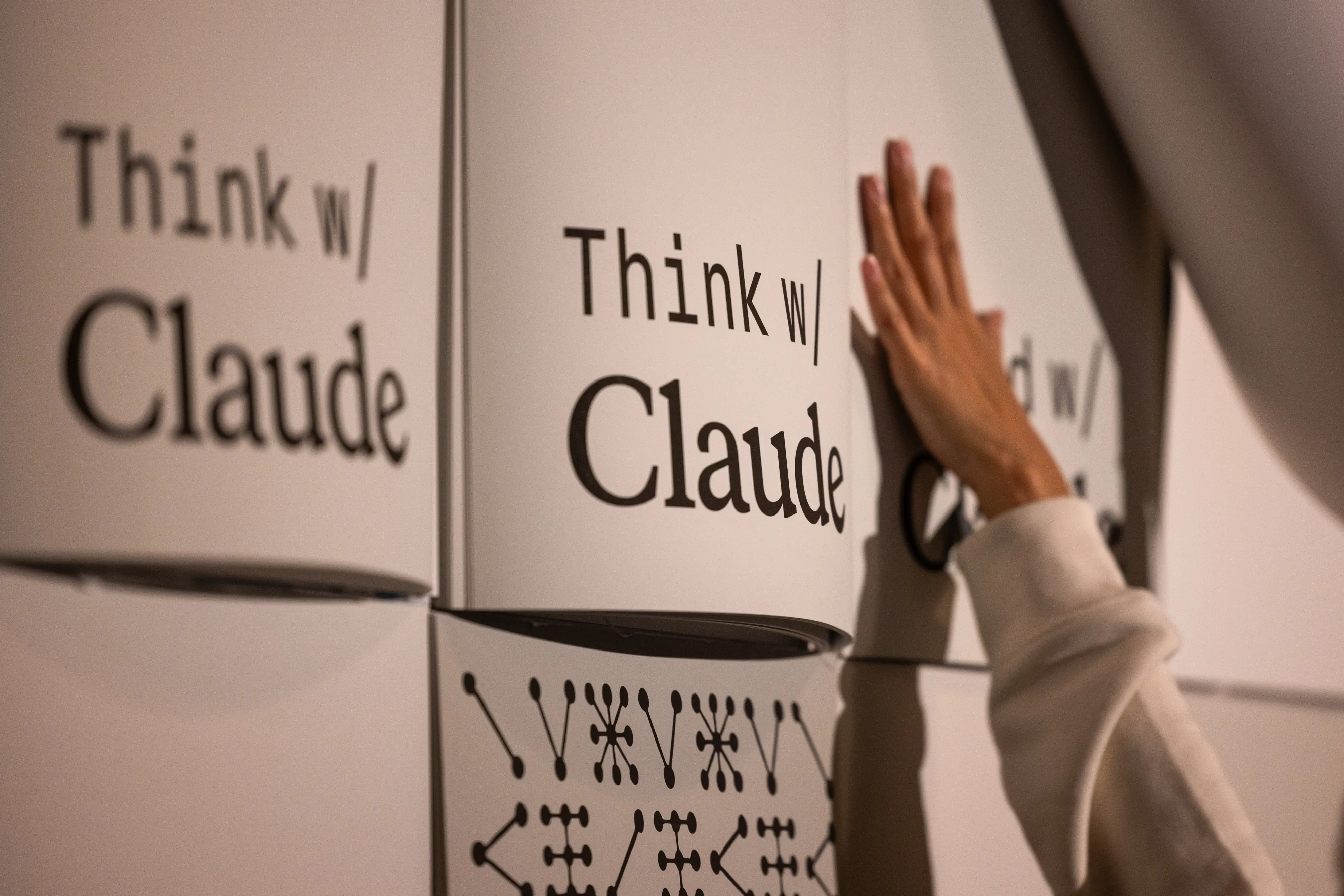 A hand touches a wall that says 