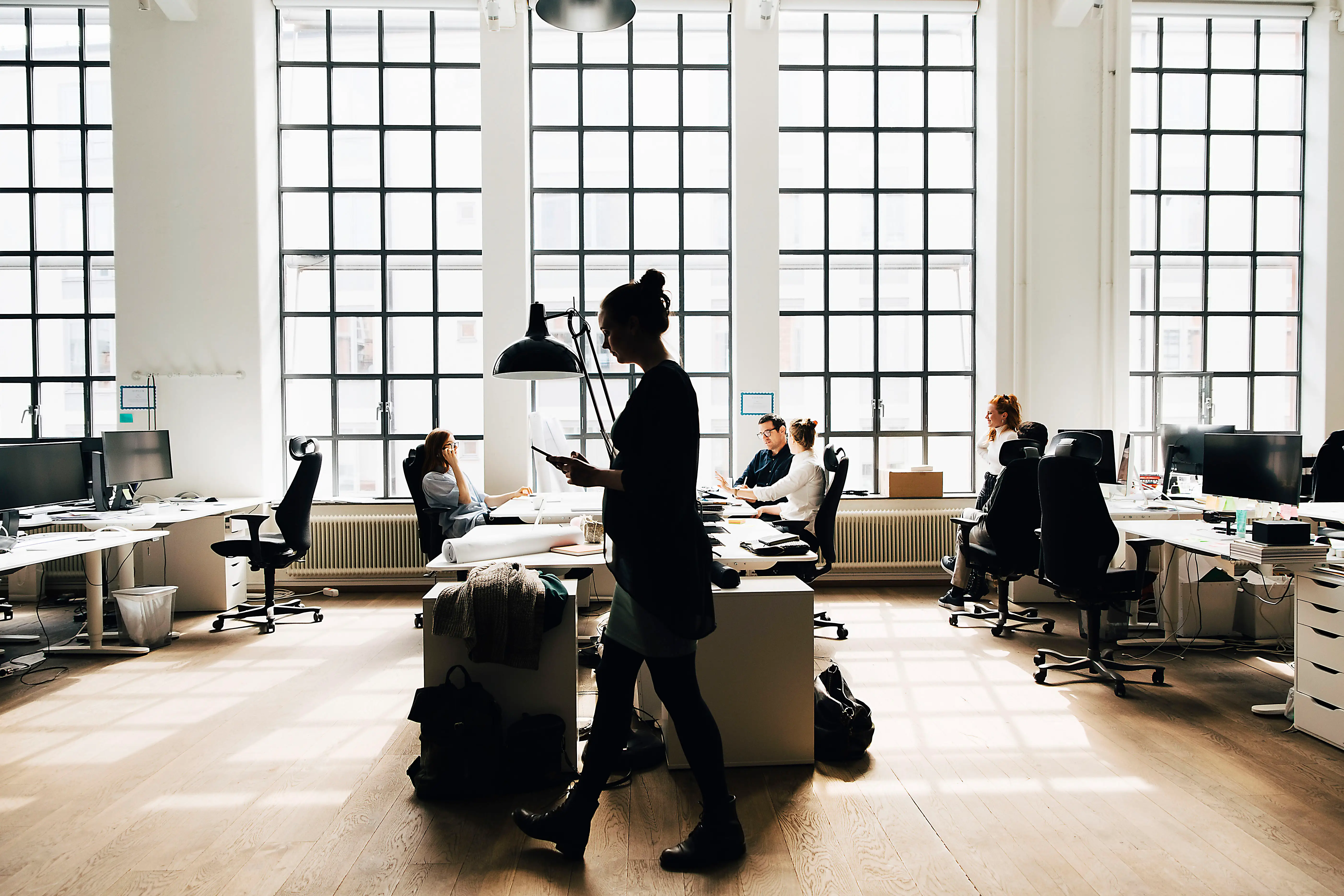 Male and female business colleagues working against window in office