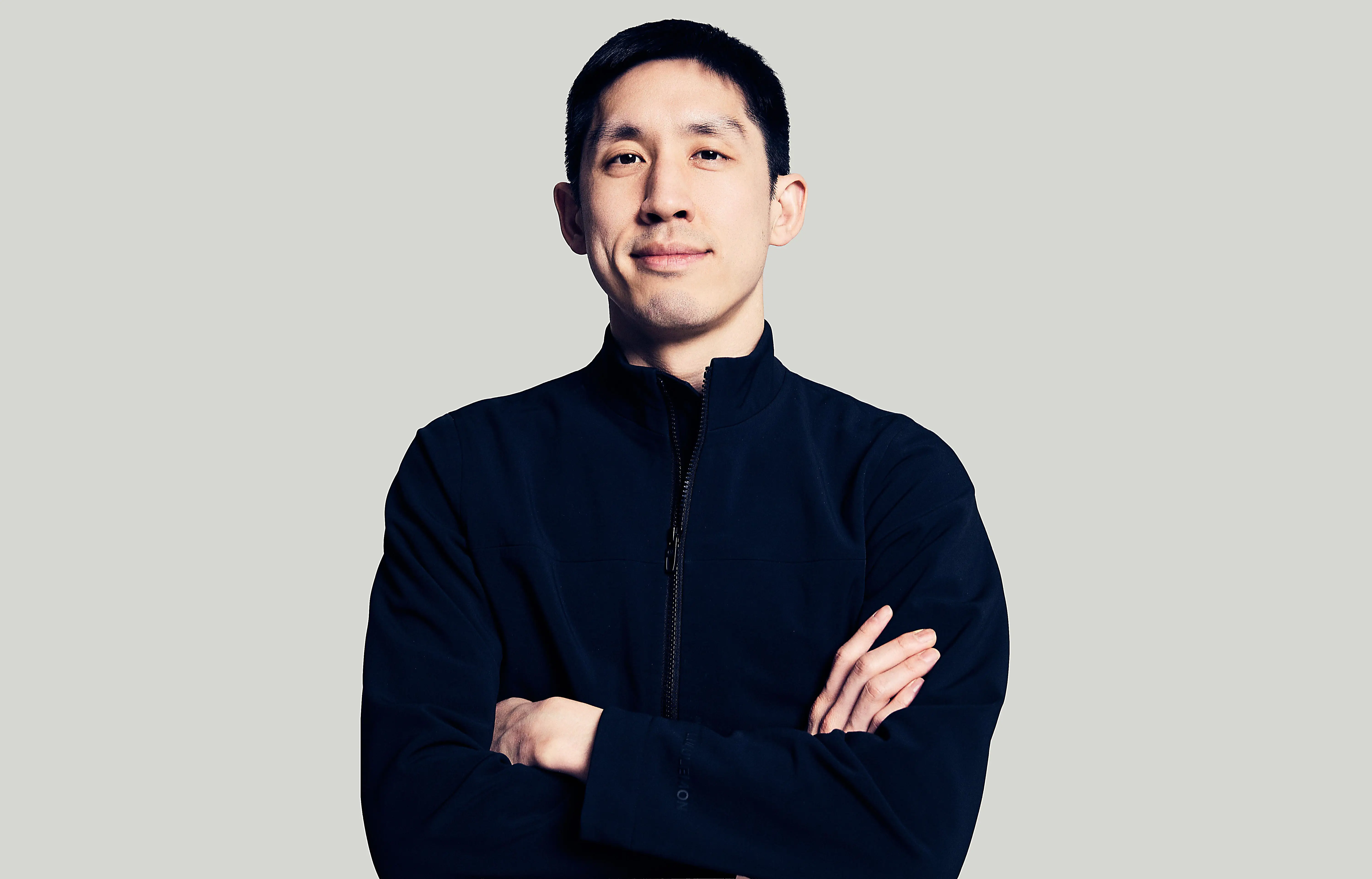 The CEO of Valon, Andrew Wang, stands with his arms folded. He's wearing all black.