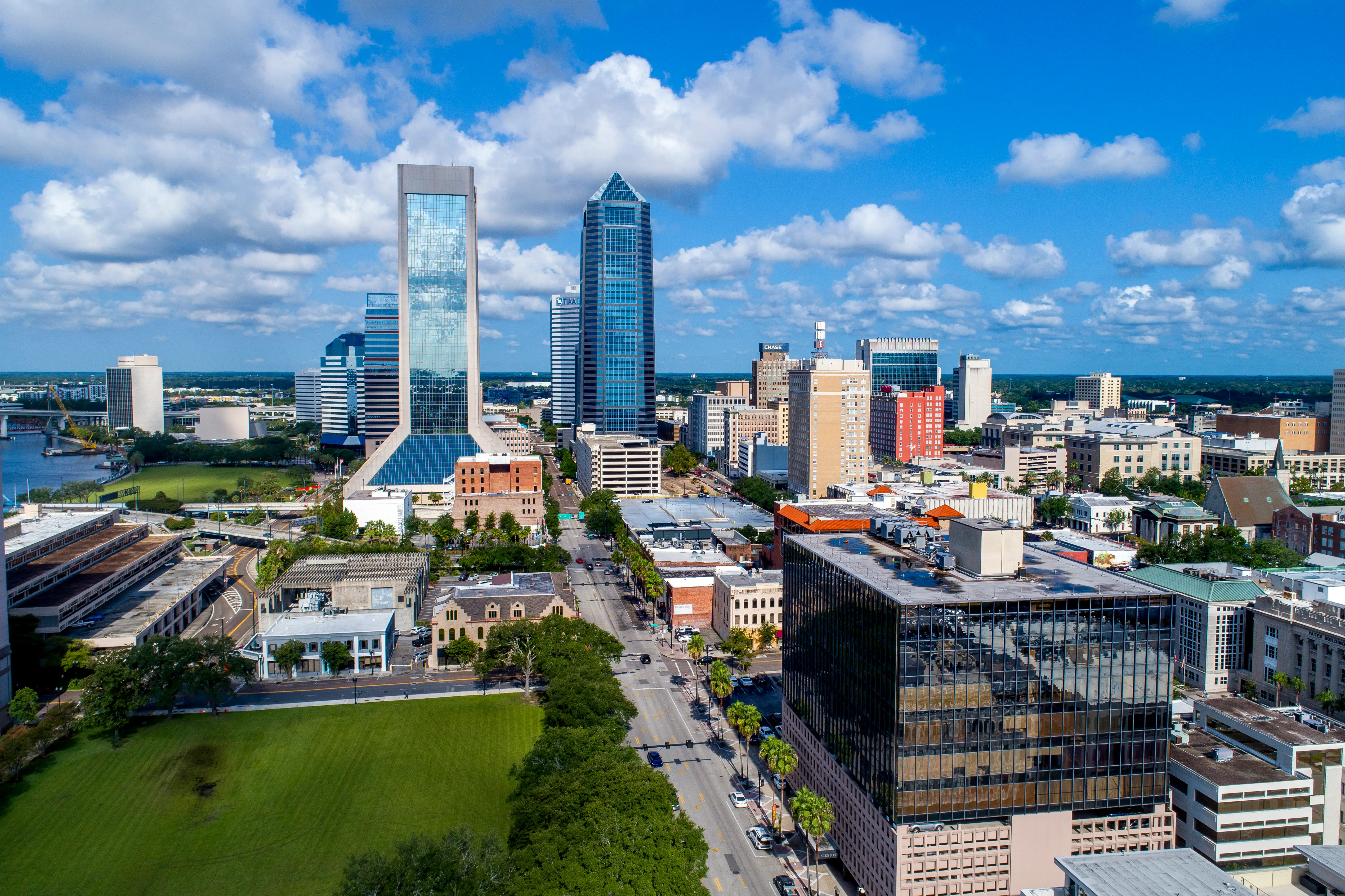 Downtown Jacksonville skyline with high-rise towers, streets, under a cloudy sky.