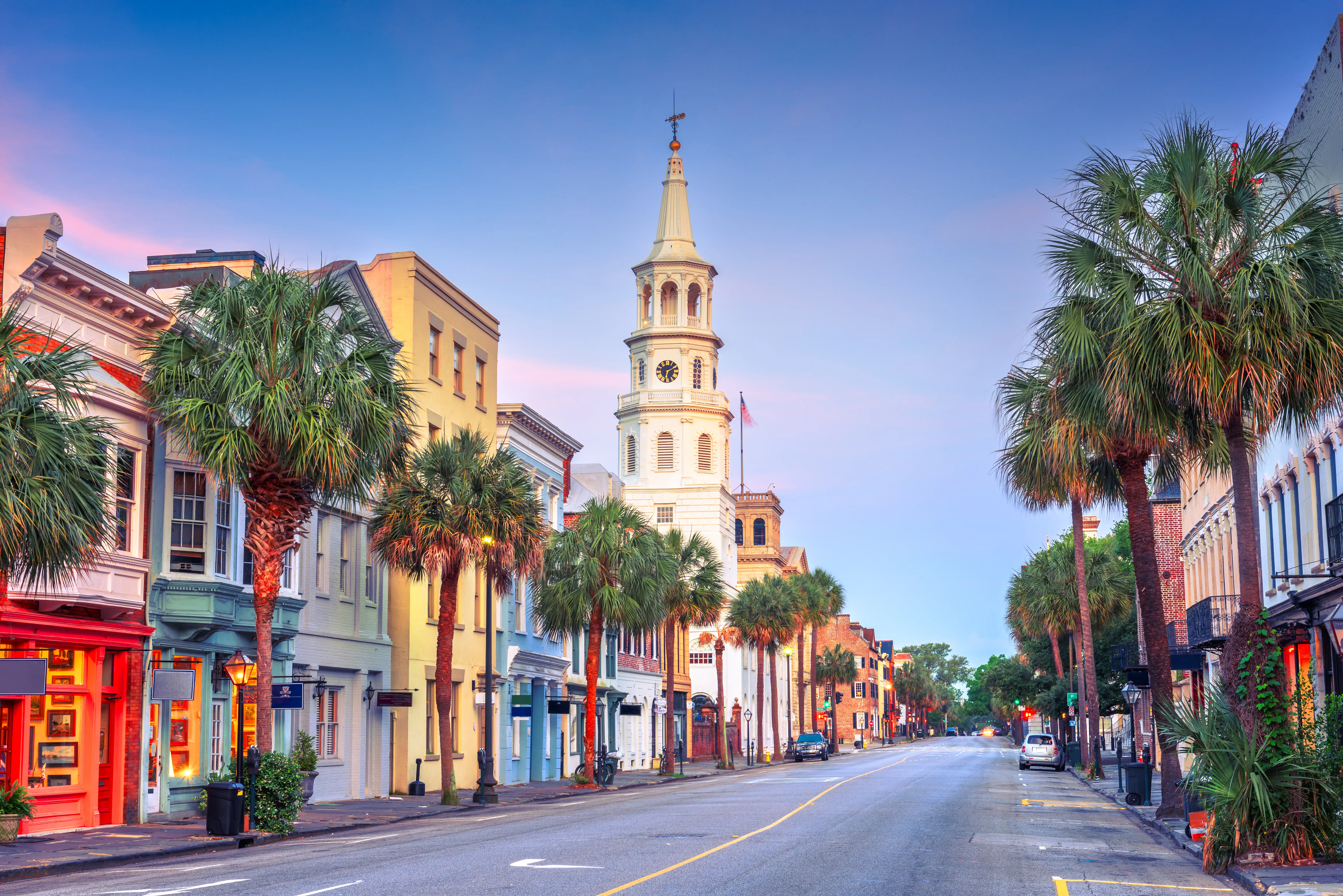 Historic Charleston street lined with palm trees and colorful buildings.