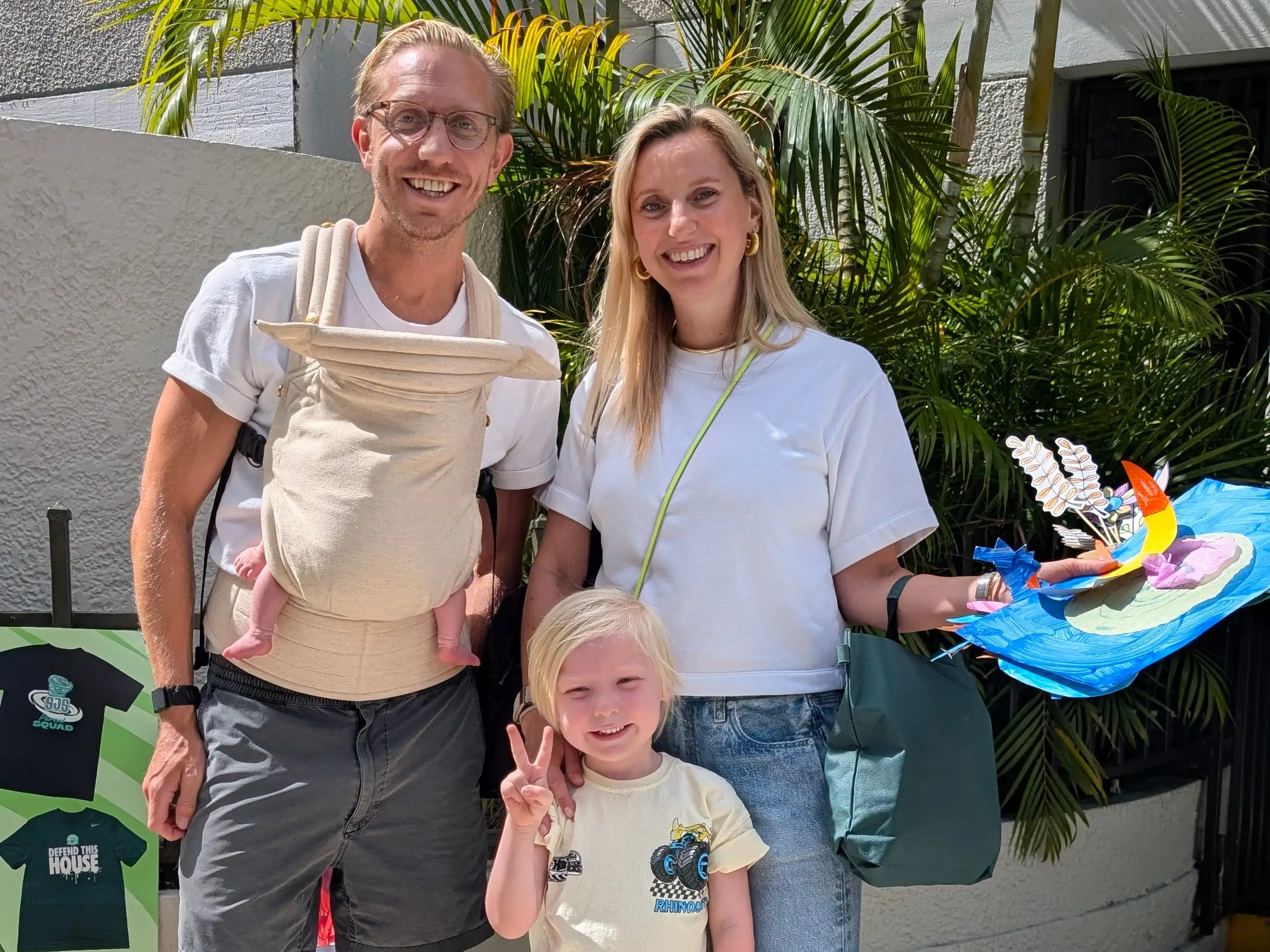 Man with baby in baby carrier posing with woman and child
