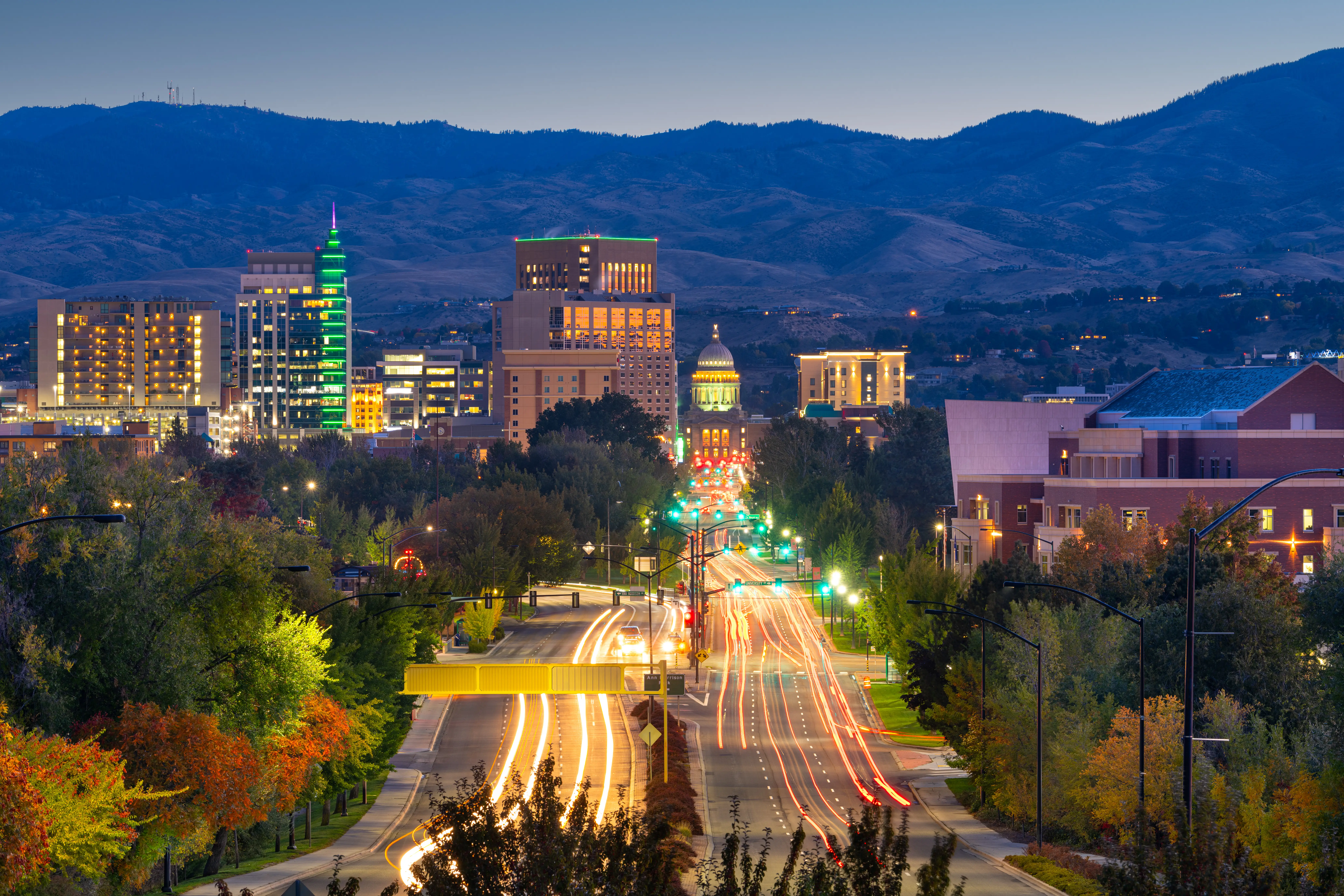 Downtown Boise skyline at dusk with light trails leading toward the Idaho State Capitol.
