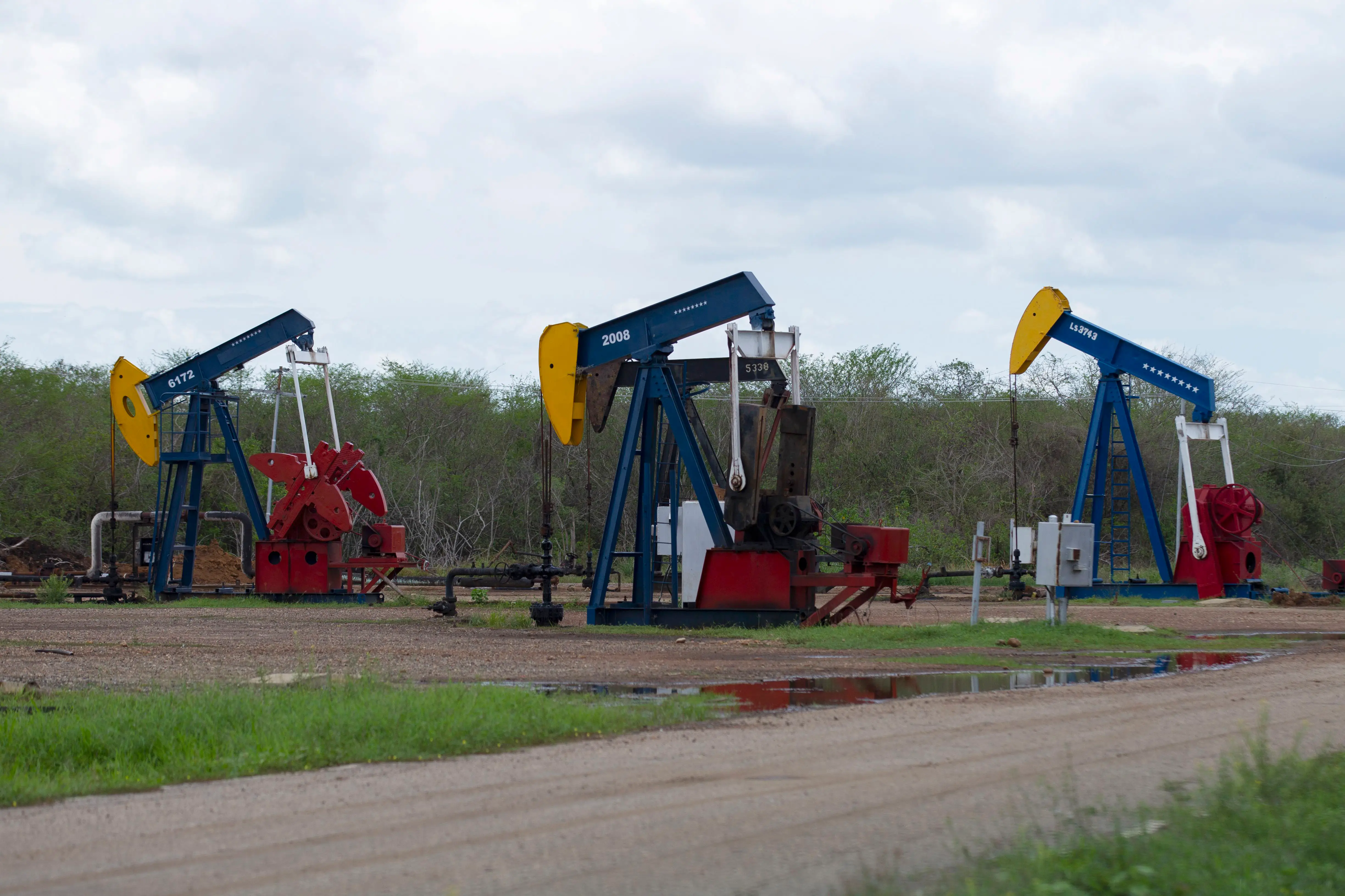 Lagunillas, Zulia, Venezuela. April 28, 2026. Oil pumping hammers are seen in the oil field, painted with the colors of the Venezuelan flag. Dozens of families live in houses that were given to them by the oil company, and which, due to the extraction of crude oil near the Campo Alegria urbanization, have been collapsing, due to the fracking that they